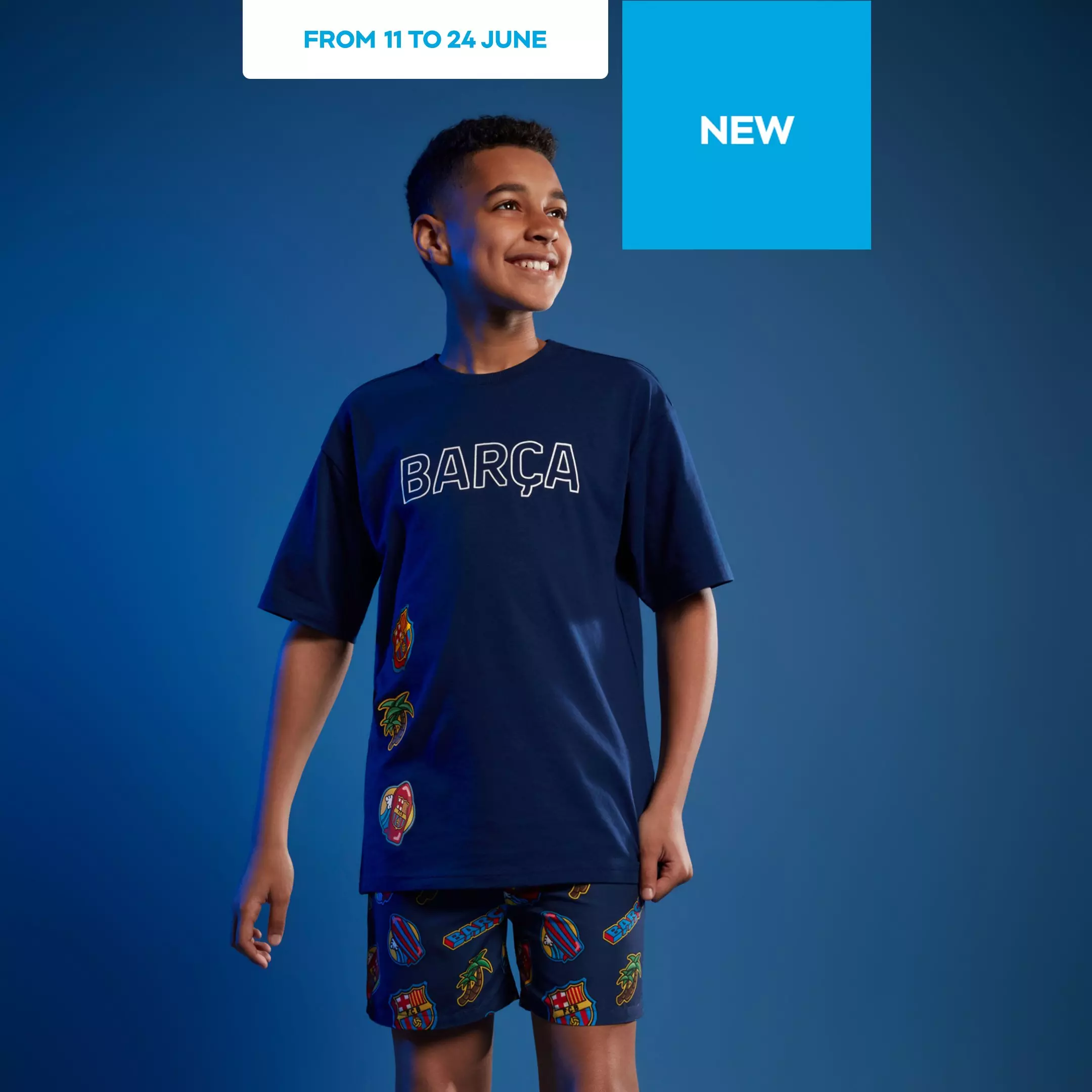 Pepco boy smiling wearing navy BARÇA t-shirt and matching shorts with football club badges.