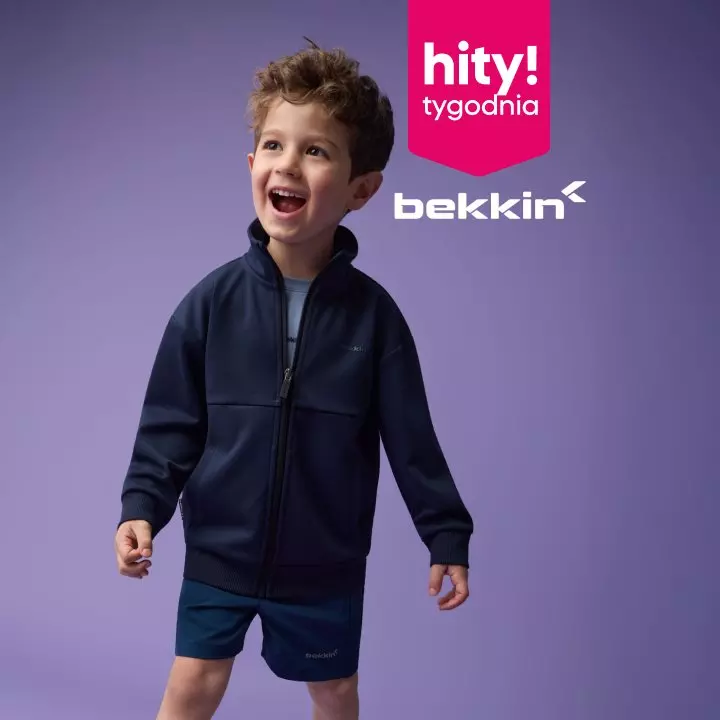 Chłopiec w granatowej bluzie i szortach Bekkin z kolekcji Pepco, uśmiechnięty.
