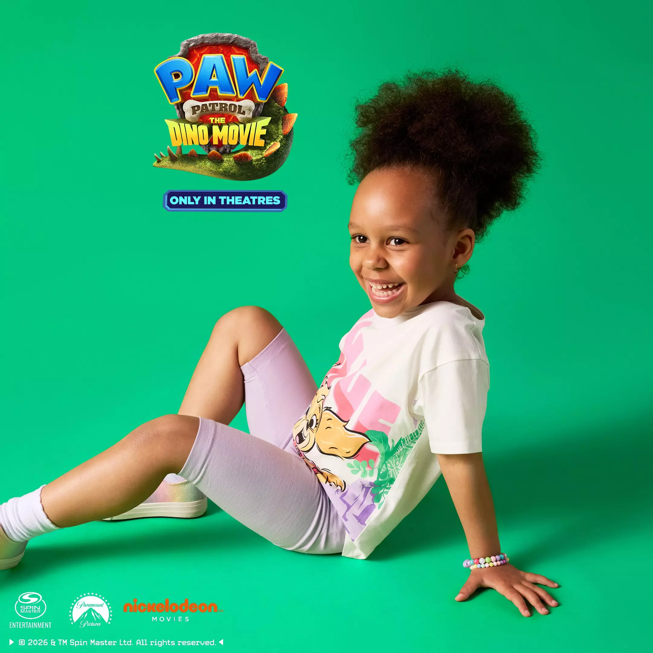 Niña sonriente de Pepco vistiendo conjunto de PAW Patrol The Dino Movie con camiseta y leggings lila.