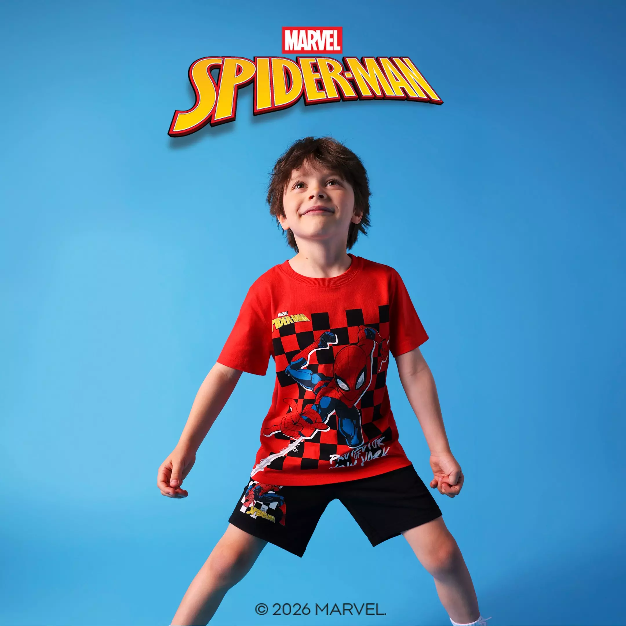 Chłopiec w czerwonej koszulce i czarnych szortach Marvel Spider-Man od Pepco, pozujący radośnie.