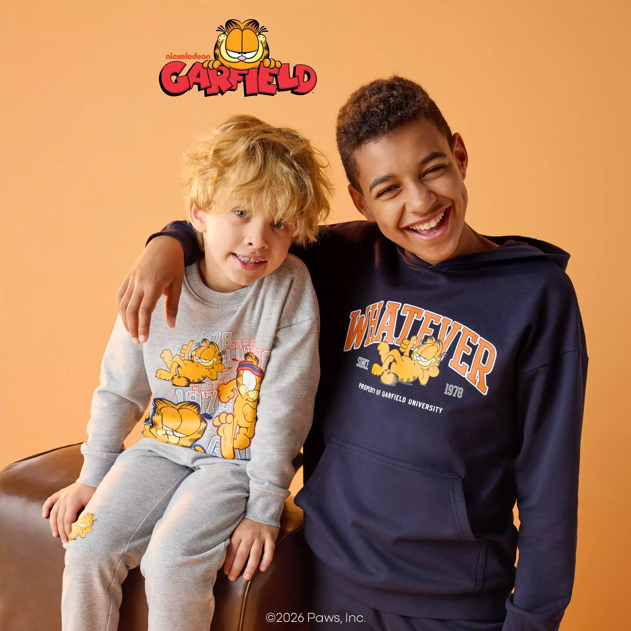 Doi băieți zâmbitori poartă îmbrăcăminte Pepco cu personajul Garfield de la Nickelodeon.
