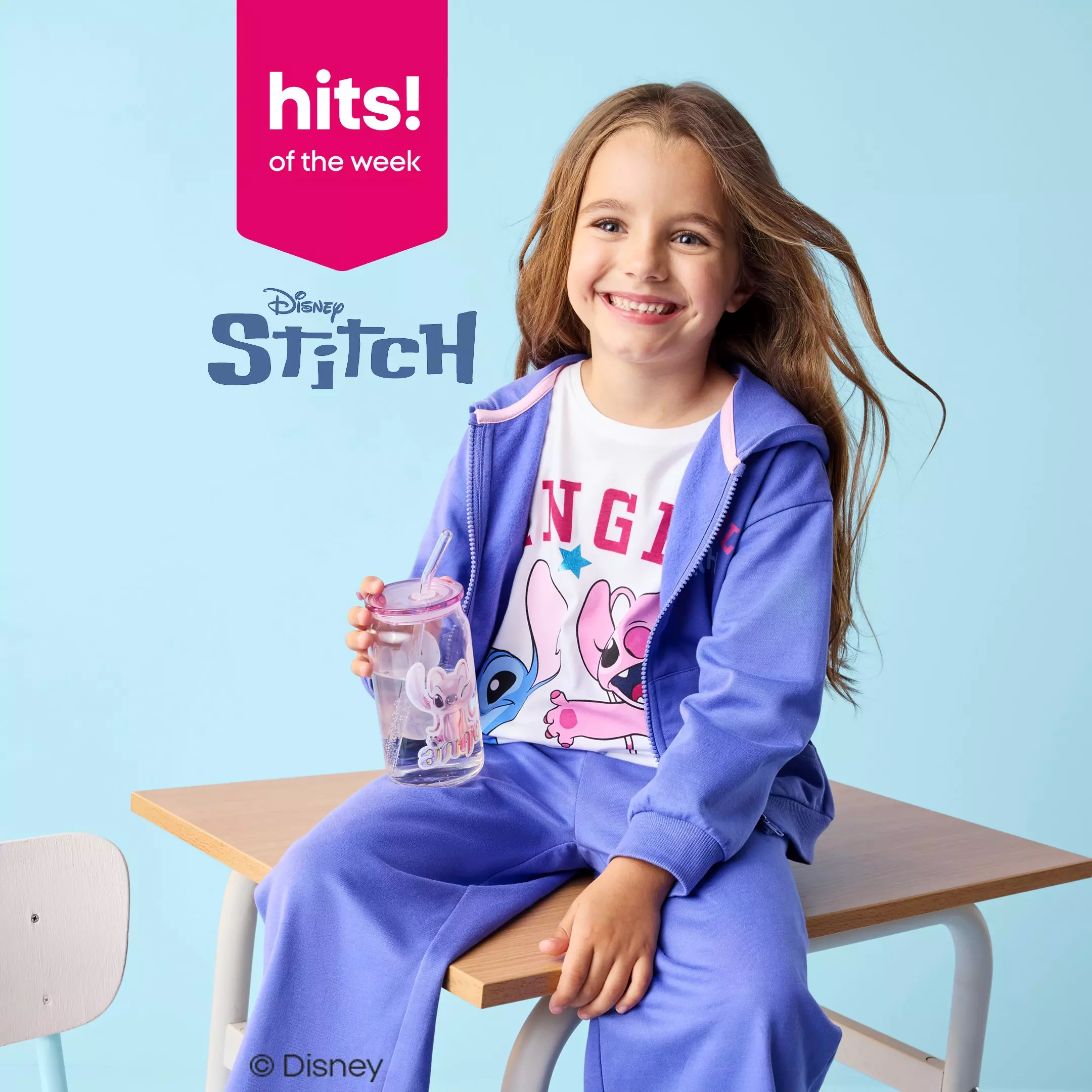 Pepco girl wearing purple Disney Stitch tracksuit and character t-shirt, holding a drink cup and smiling.