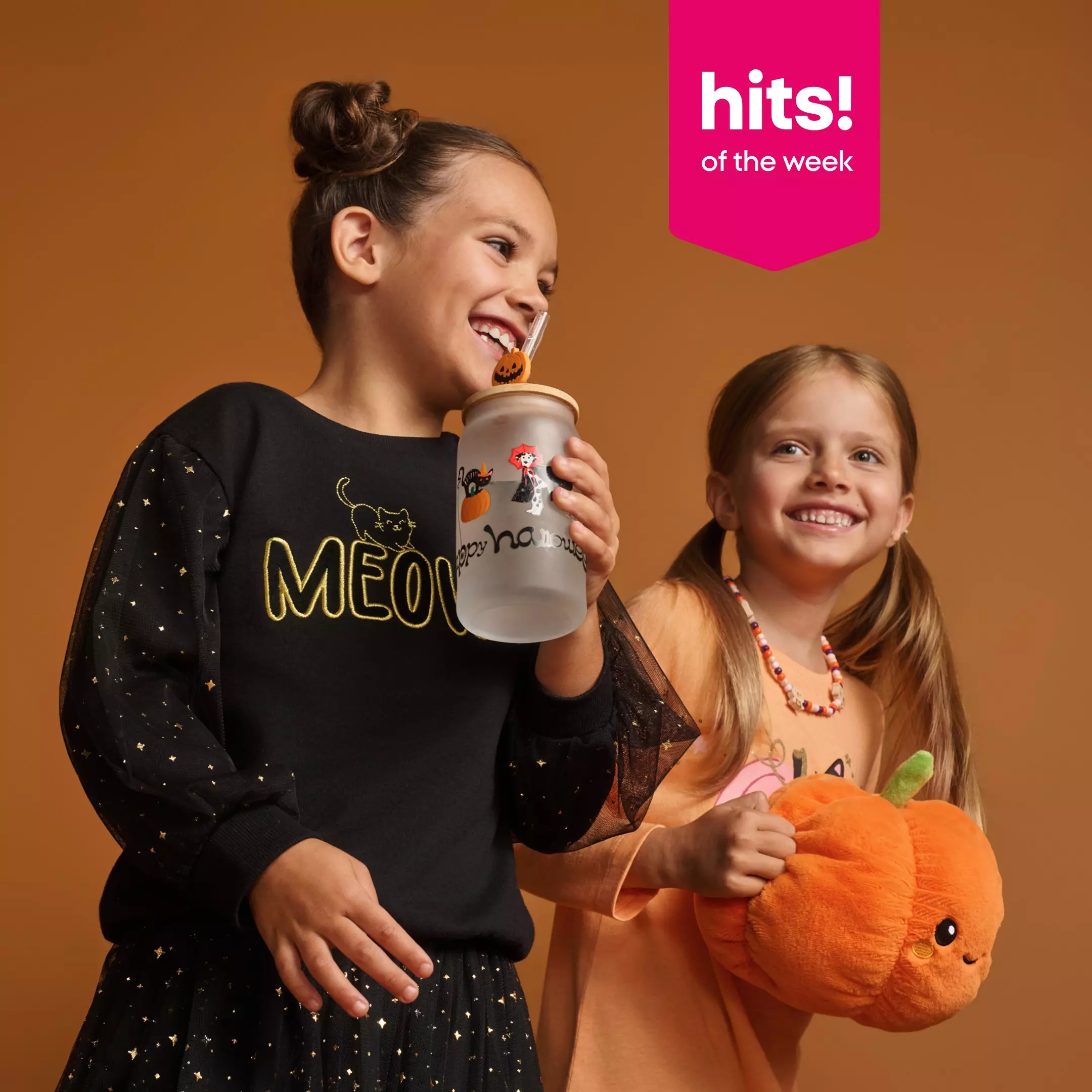 Pepco girls wearing Halloween outfits, one holding a water bottle and the other holding a pumpkin plush toy.