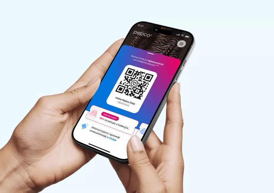 Dłonie trzymające smartfon z otwartą aplikacją Pepco, wyświetlającą kod QR dla programu lojalnościowego Pepco Club.