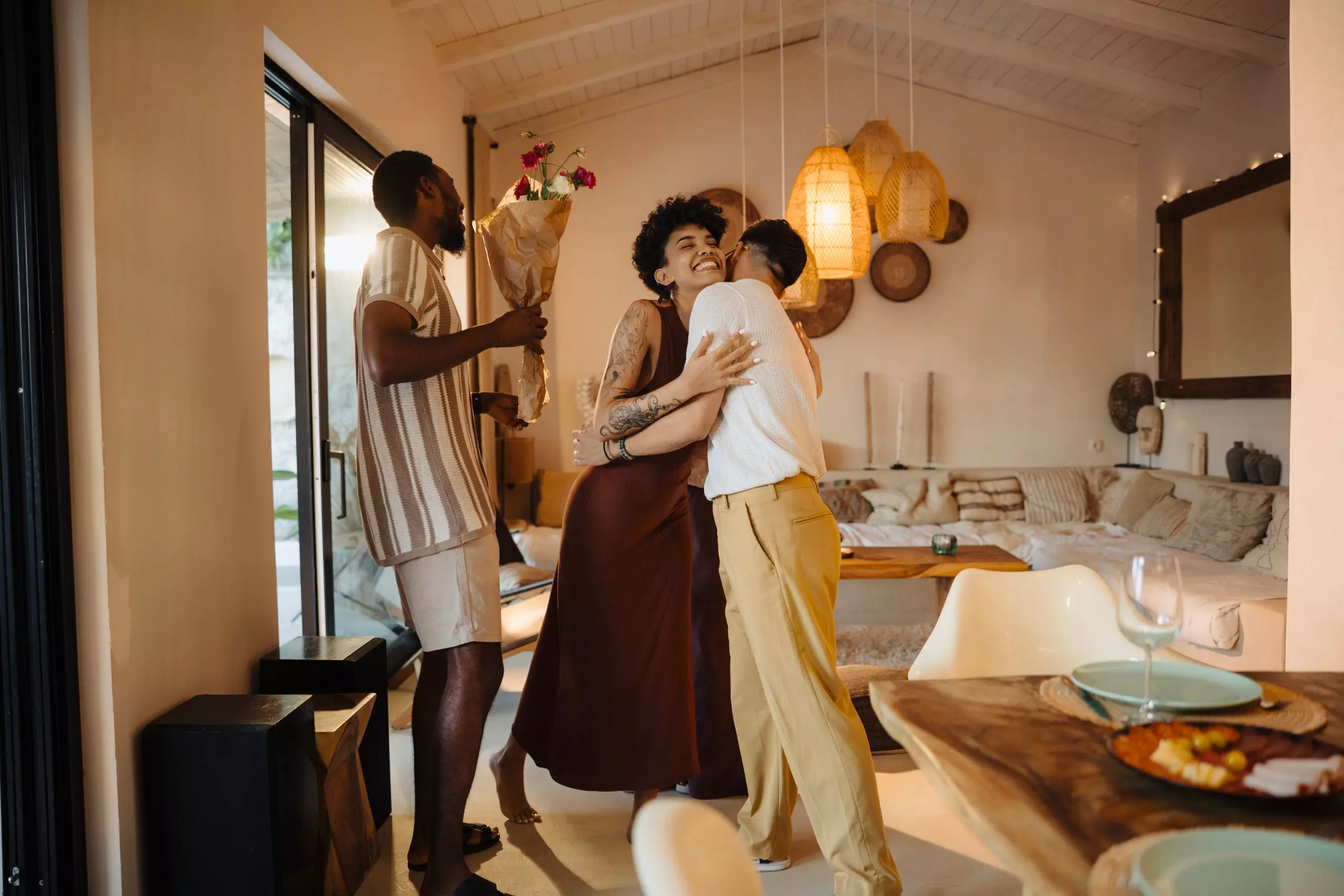Pepco homeware styled in a warm dining room where friends embrace and celebrate with flowers.