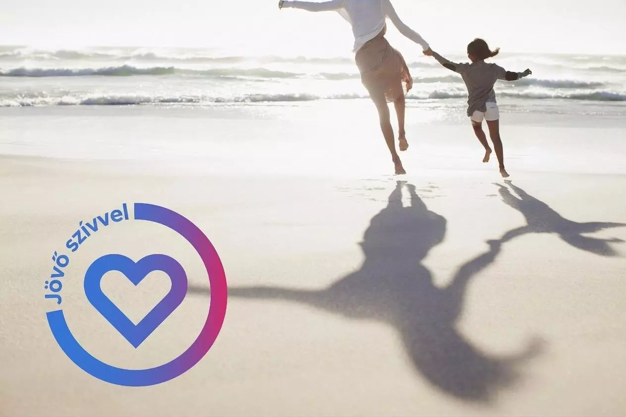 Felnőtt és gyermek kézen fogva ugrálnak a tengerparton, Jövő szívvel logóval.