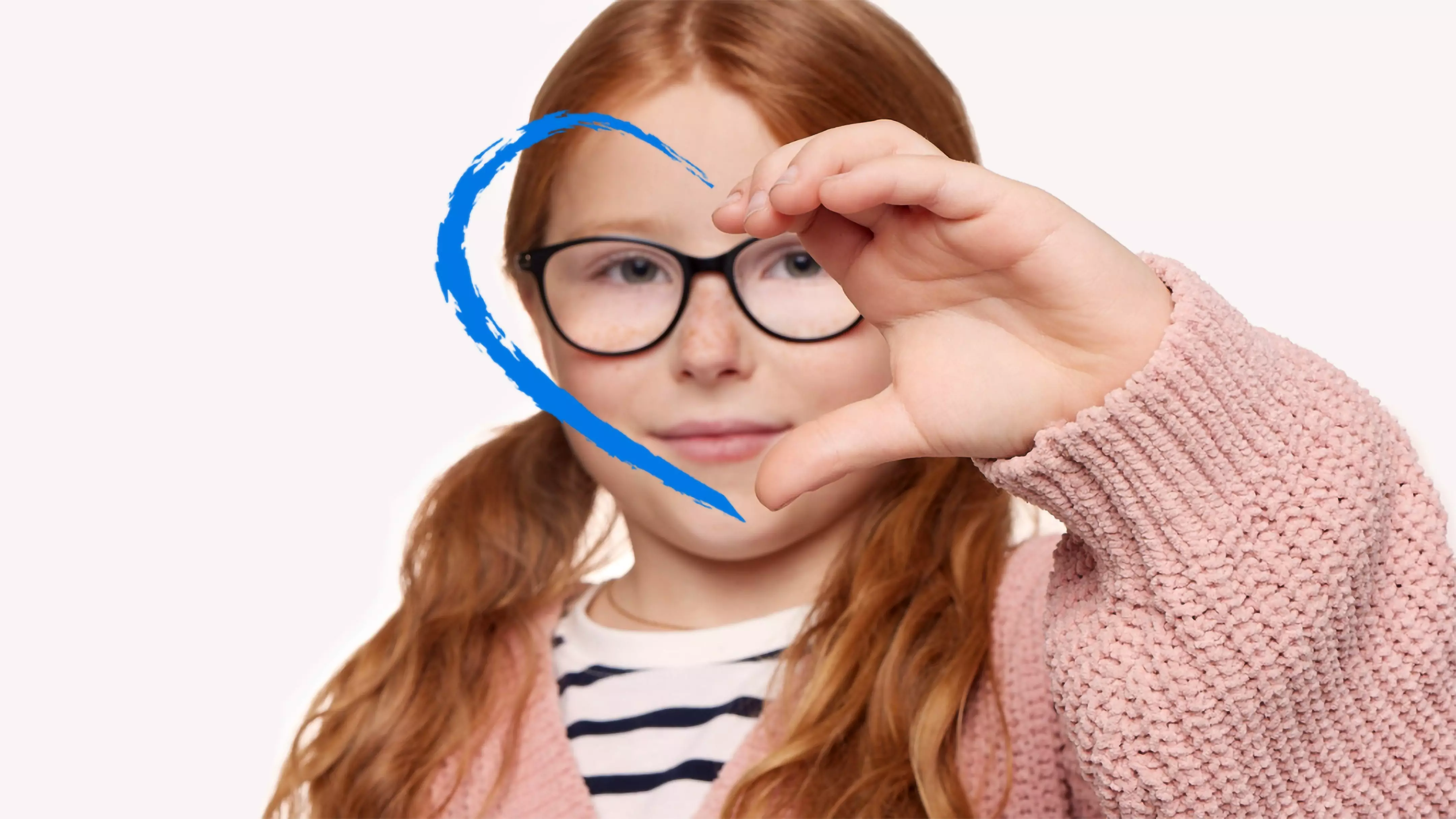 Child wearing glasses and pink Pepco sweater making heart shape with hands, wearing striped top underneath.