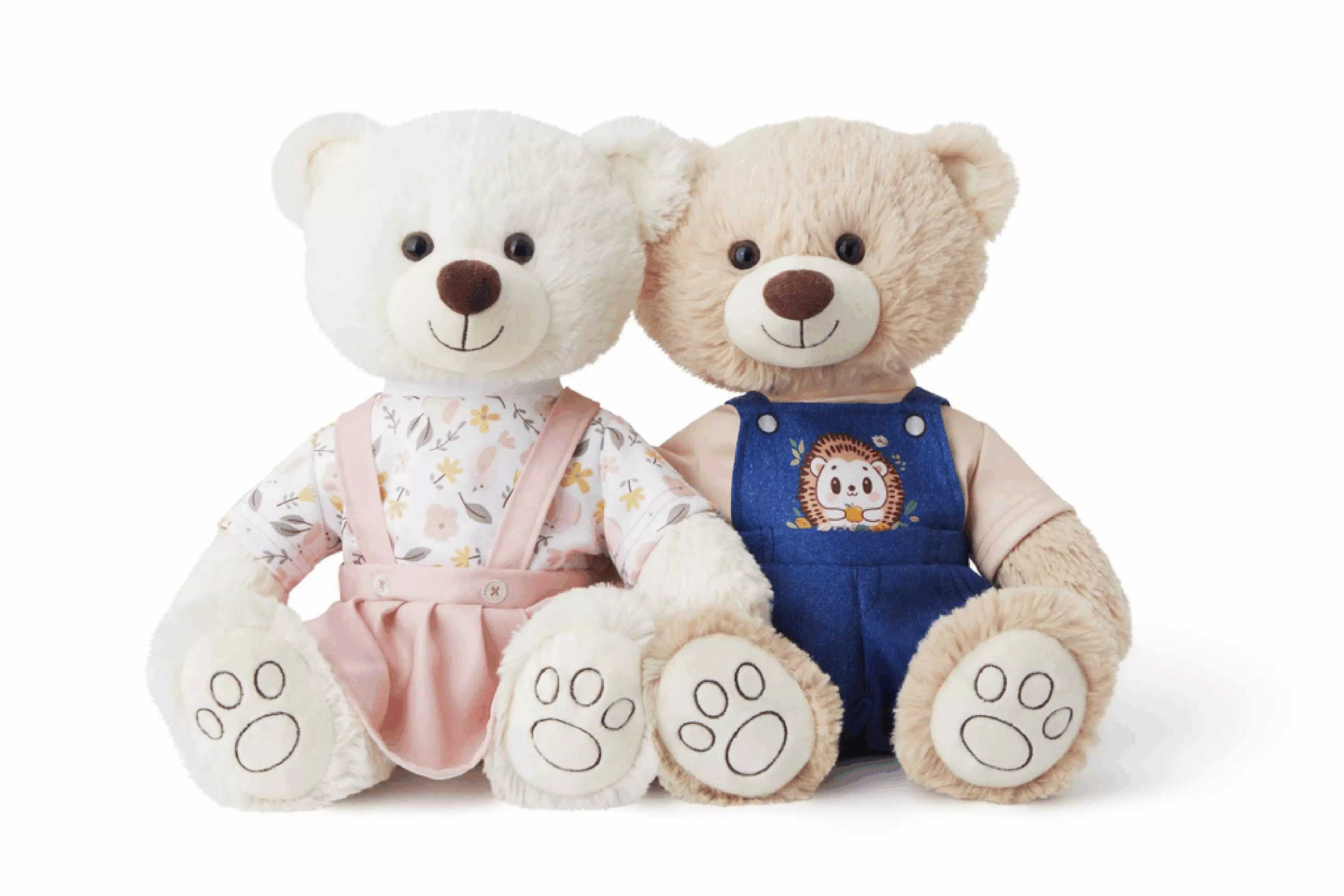 Pepco plush teddy bears - white bear in pink floral outfit and beige bear in blue overalls with hedgehog design.