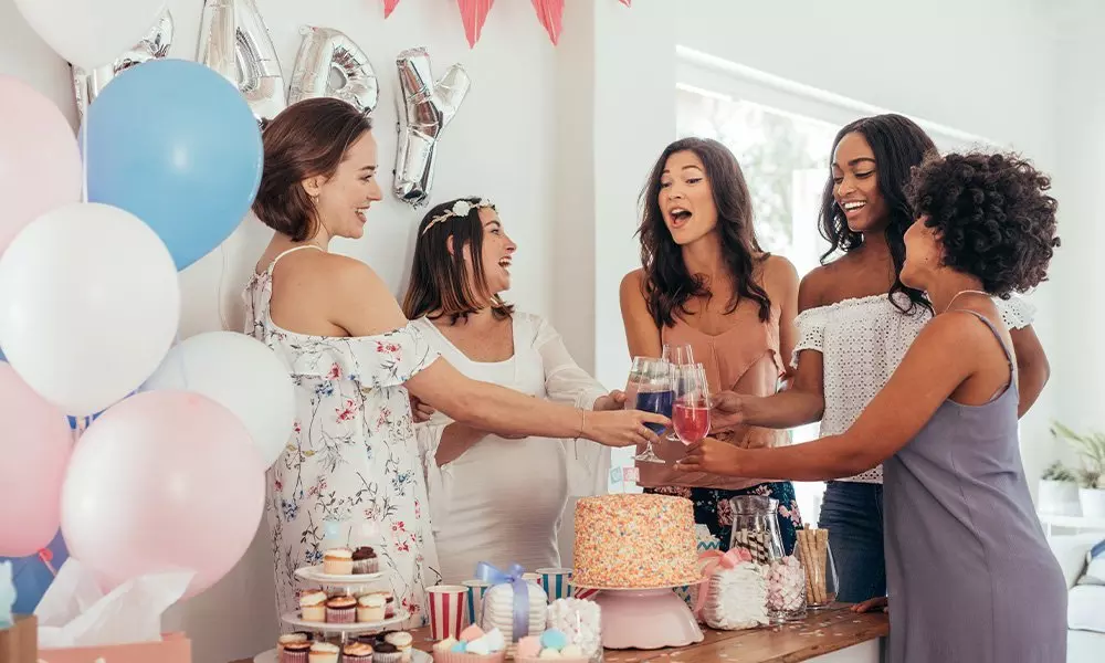 Grupa przyjaciół wznosi toast na przyjęciu z dekoracjami Pepco, kolorowym tortem i balonami w tle.