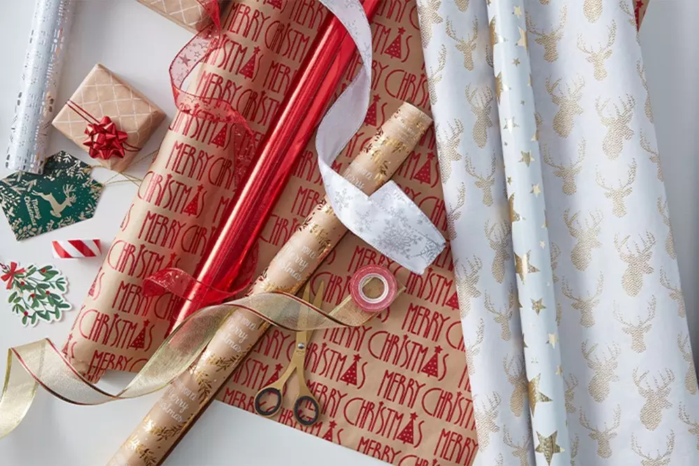 Kolekcja świątecznych papierów do pakowania Pepco z wzorami reniferów, napisami Merry Christmas oraz wstążkami i akcesoriami do dekoracji prezentów.