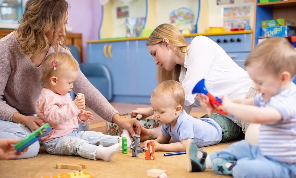 Dzieci bawiące się zabawkami edukacyjnymi Pepco w przedszkolu pod opieką opiekunek w kolorowym pomieszczeniu z meblami.