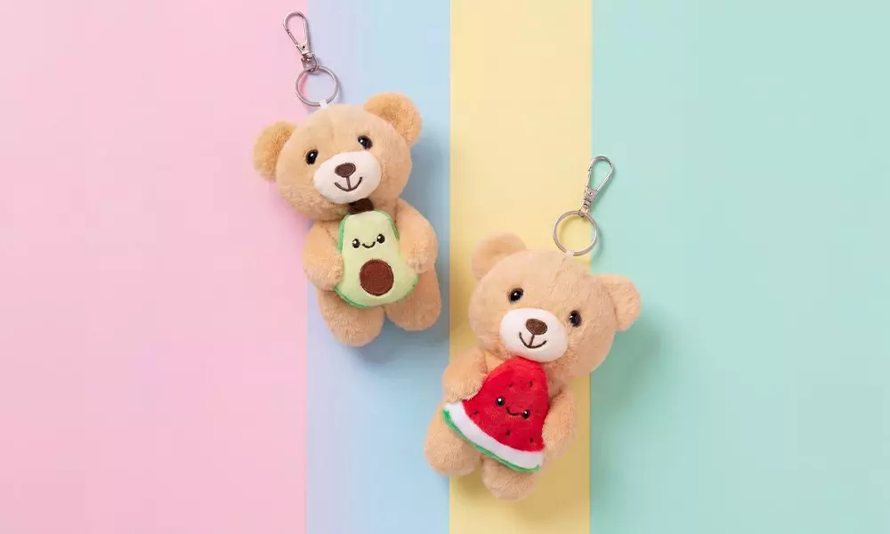 Pepco teddy bear keyrings holding avocado and watermelon plush toys with smiling faces.