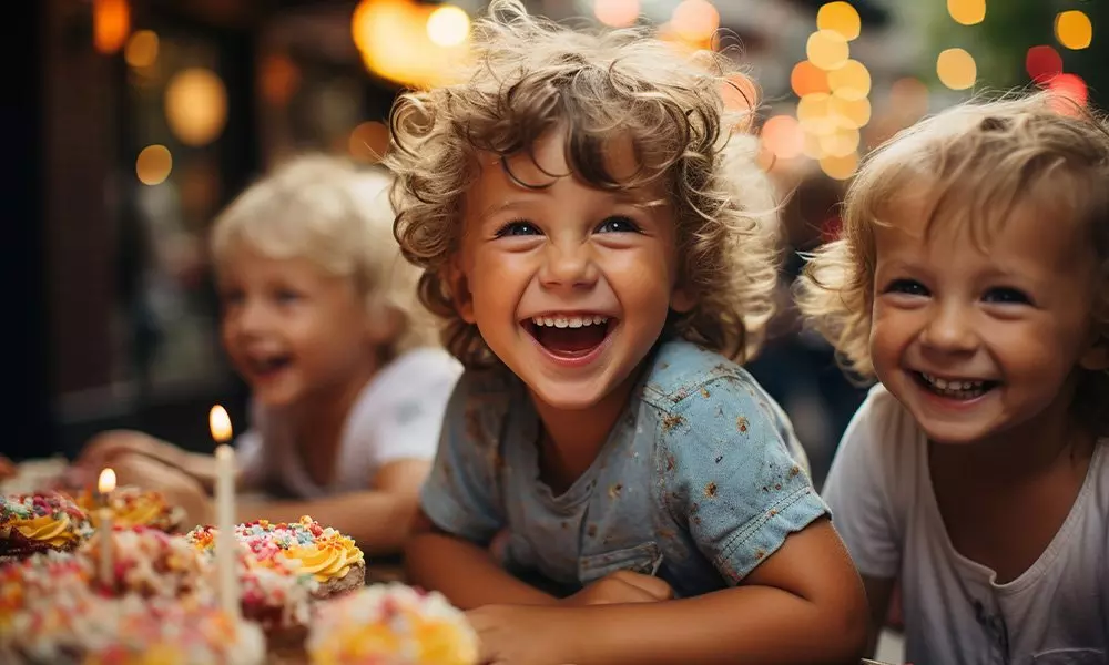 Children celebrating with a festive birthday cake from Pepco, enjoying a joyful moment with candles and colorful decorations.