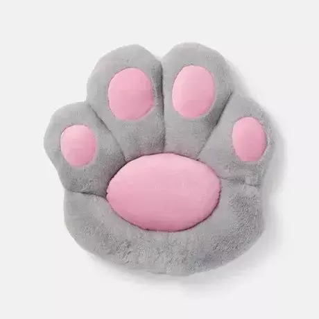 Pluszowa poduszka w kształcie kociej łapki w kolorze szarym z różowymi poduszeczkami.