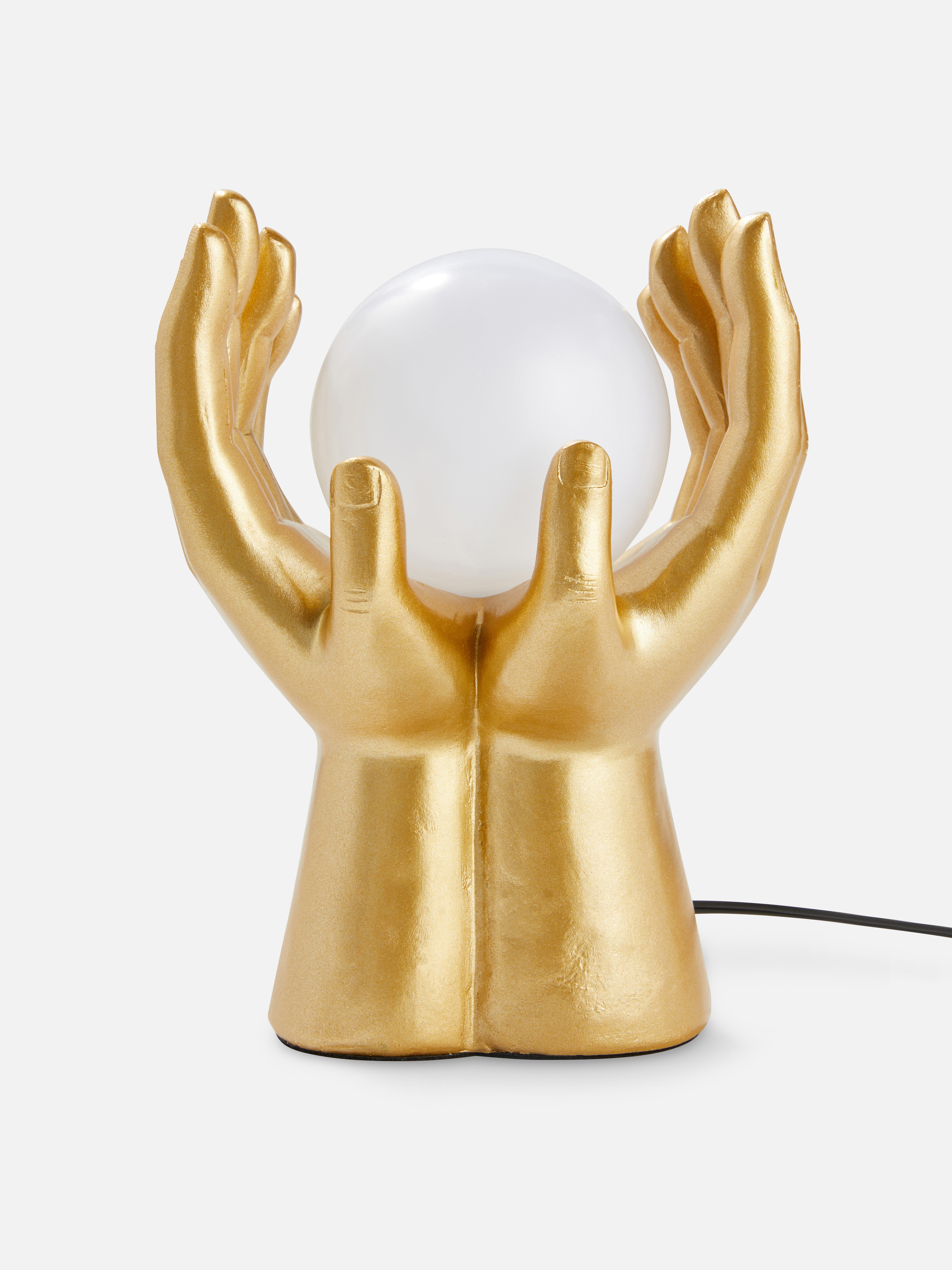 Lámpara dorada en forma de manos