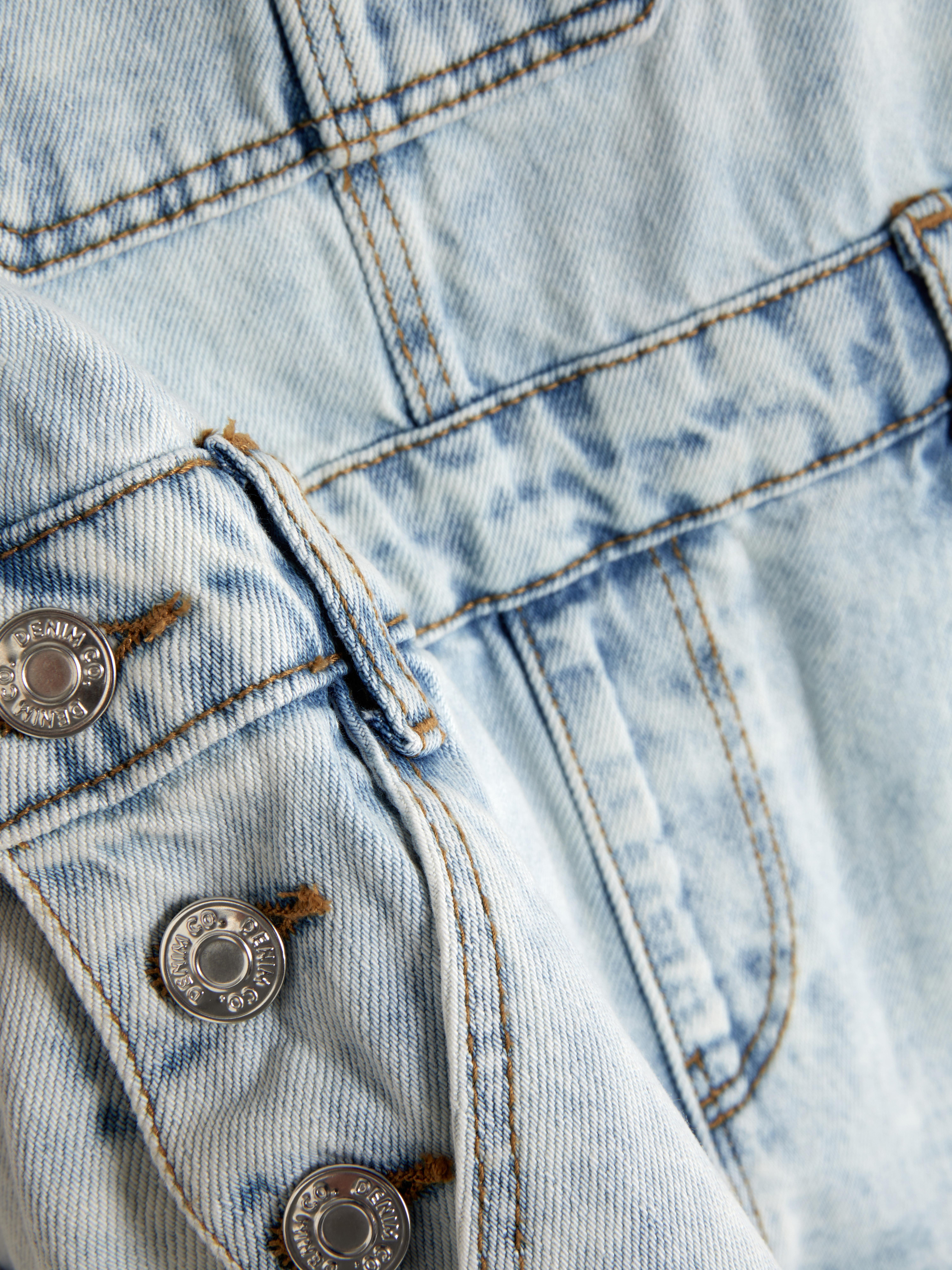 Salopette in denim con orlo sfrangiato