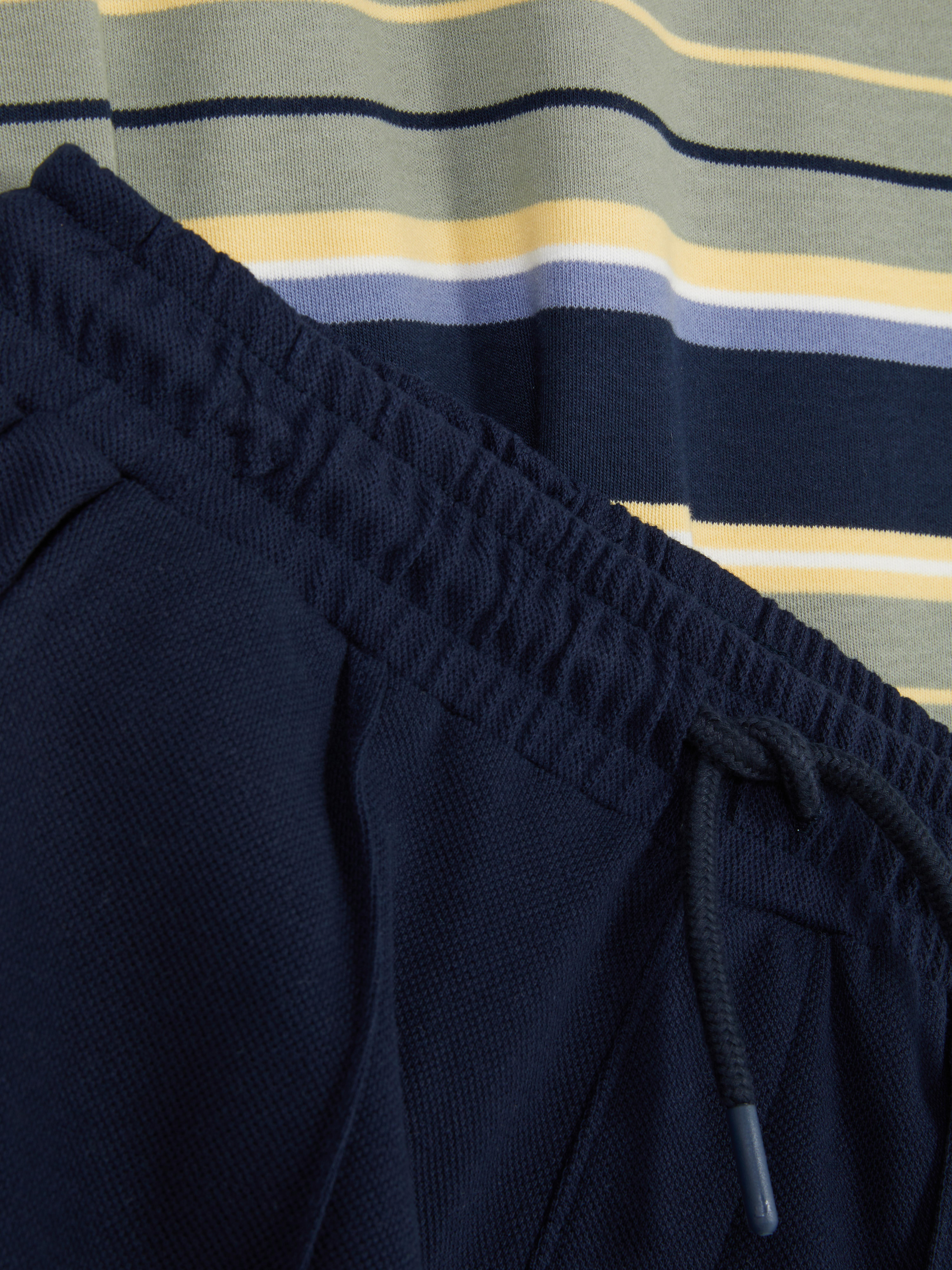 7- 15 ani | Set cu tricou în dungi și pantaloni scurți