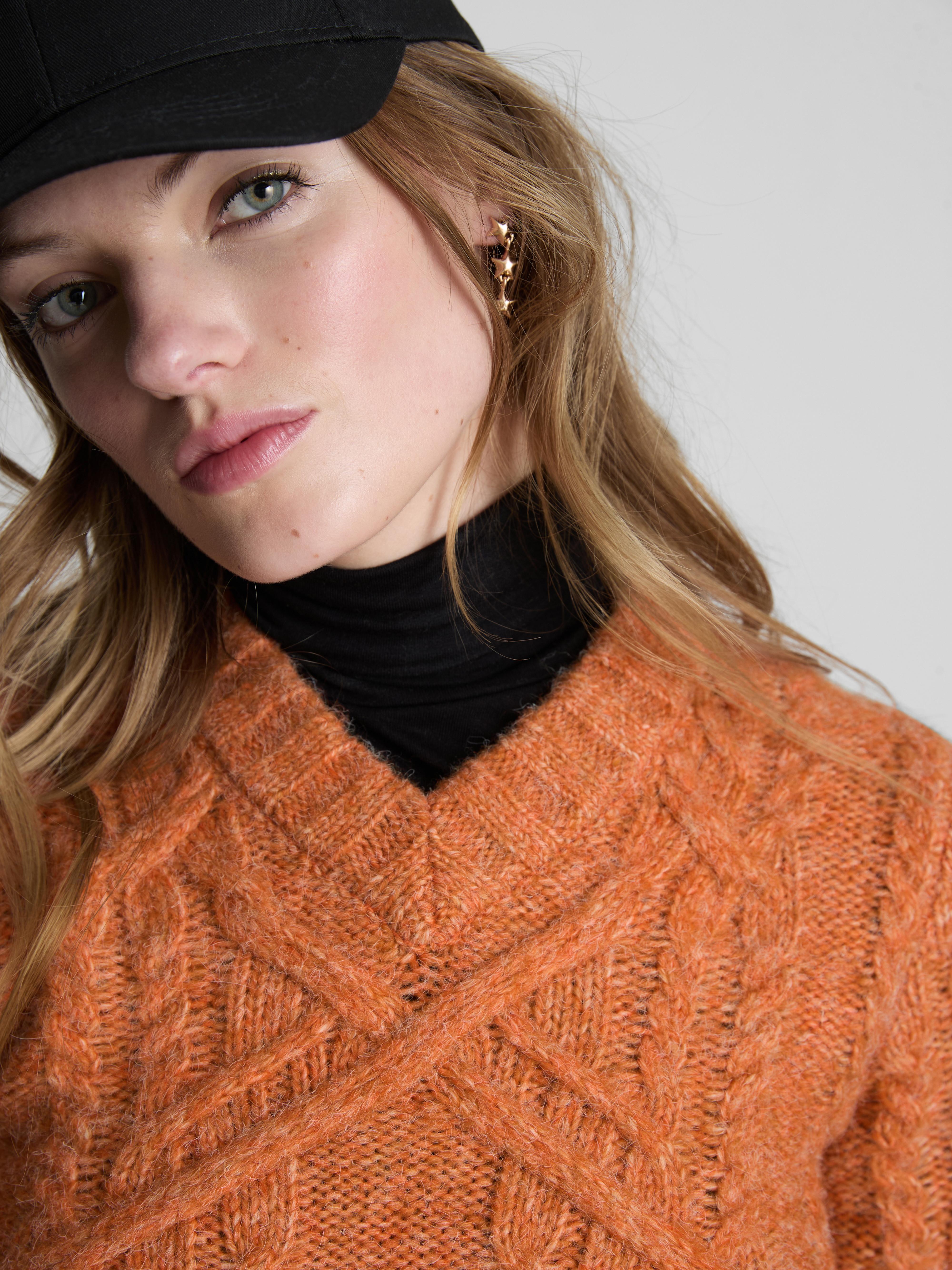 Pull court en maille torsadée à col en V