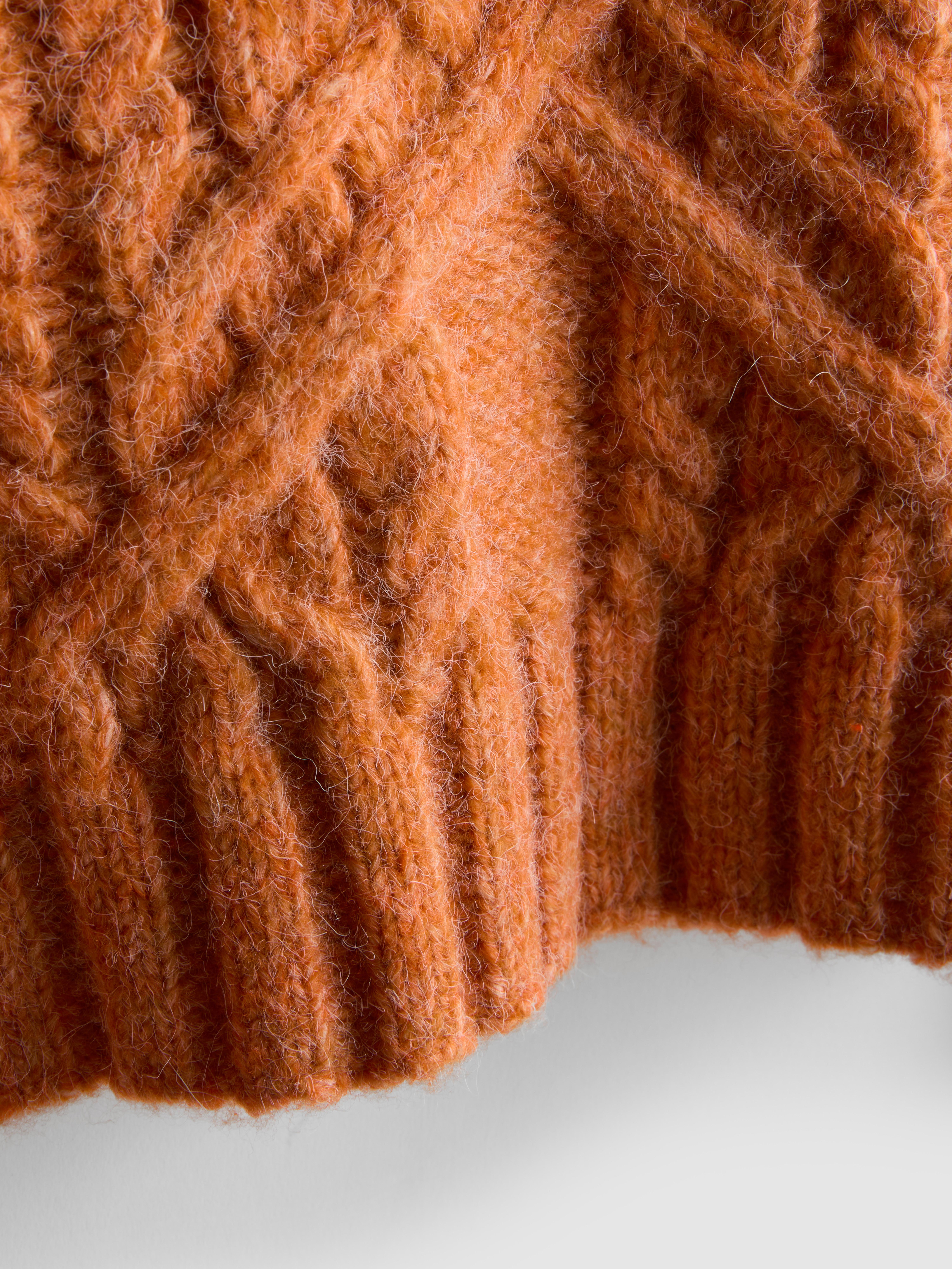 Pull court en maille torsadée à col en V