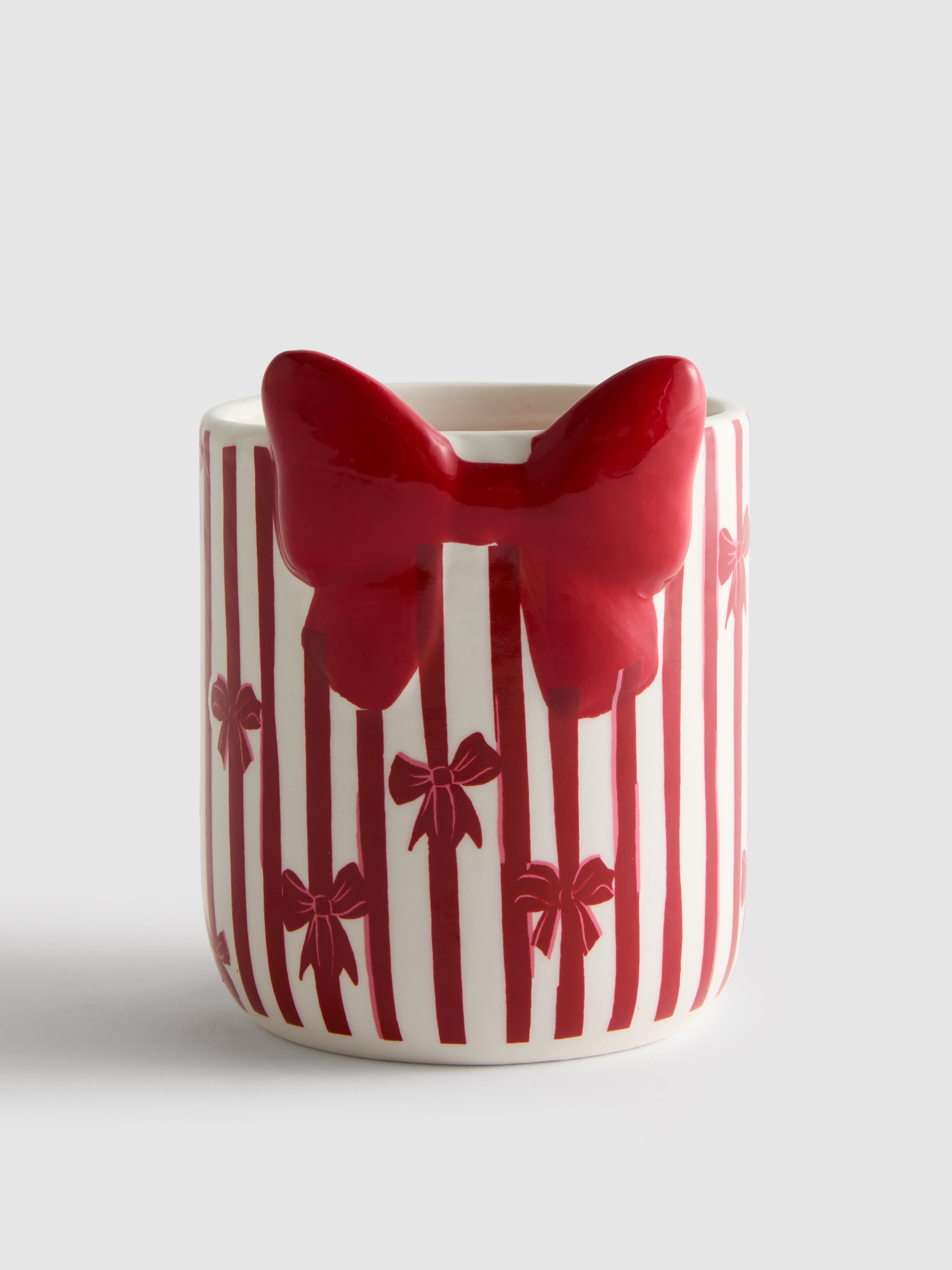Bougie parfumée dans un pot en céramique à nœuds