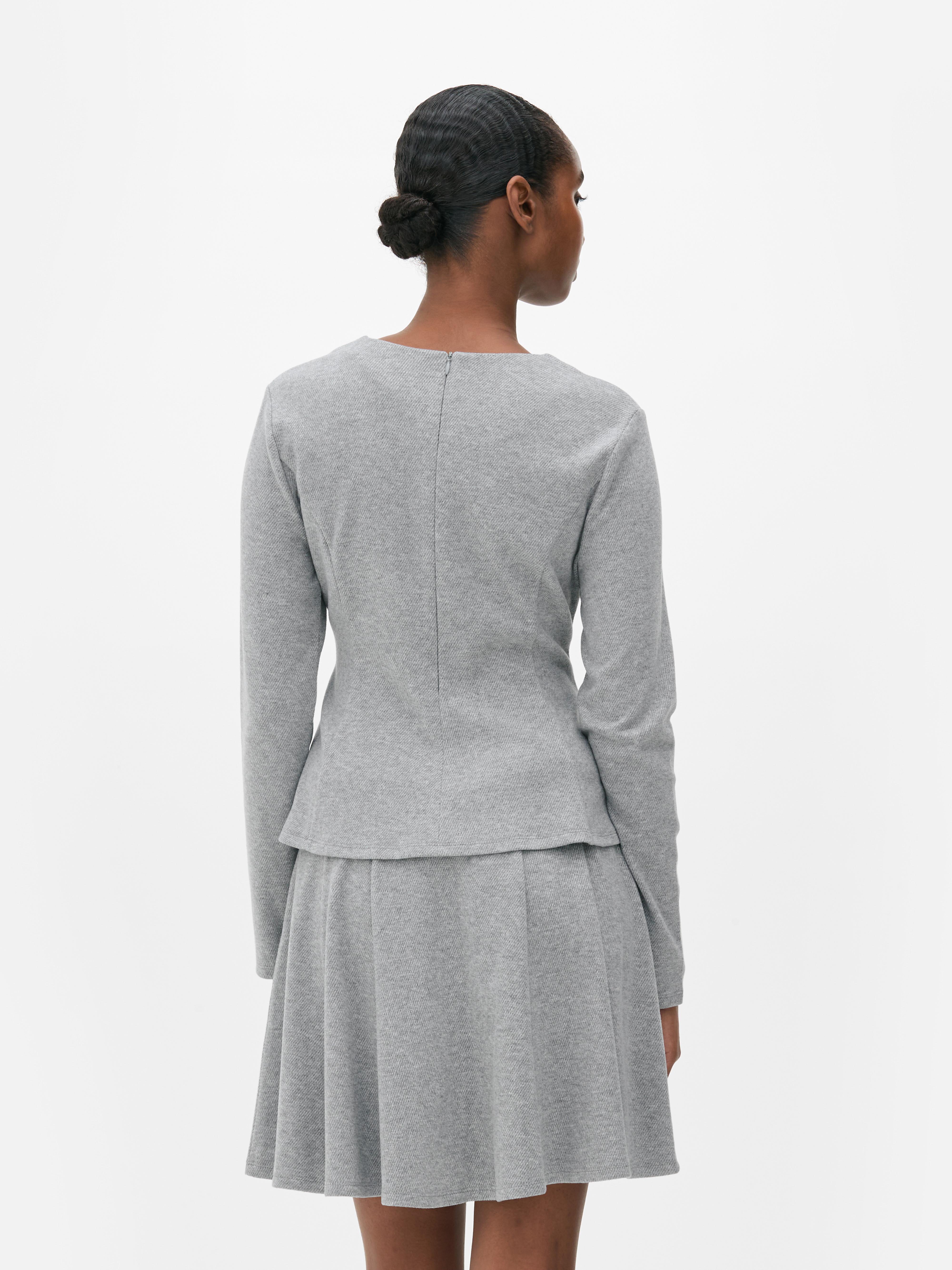 Top in peplum a maniche lunghe