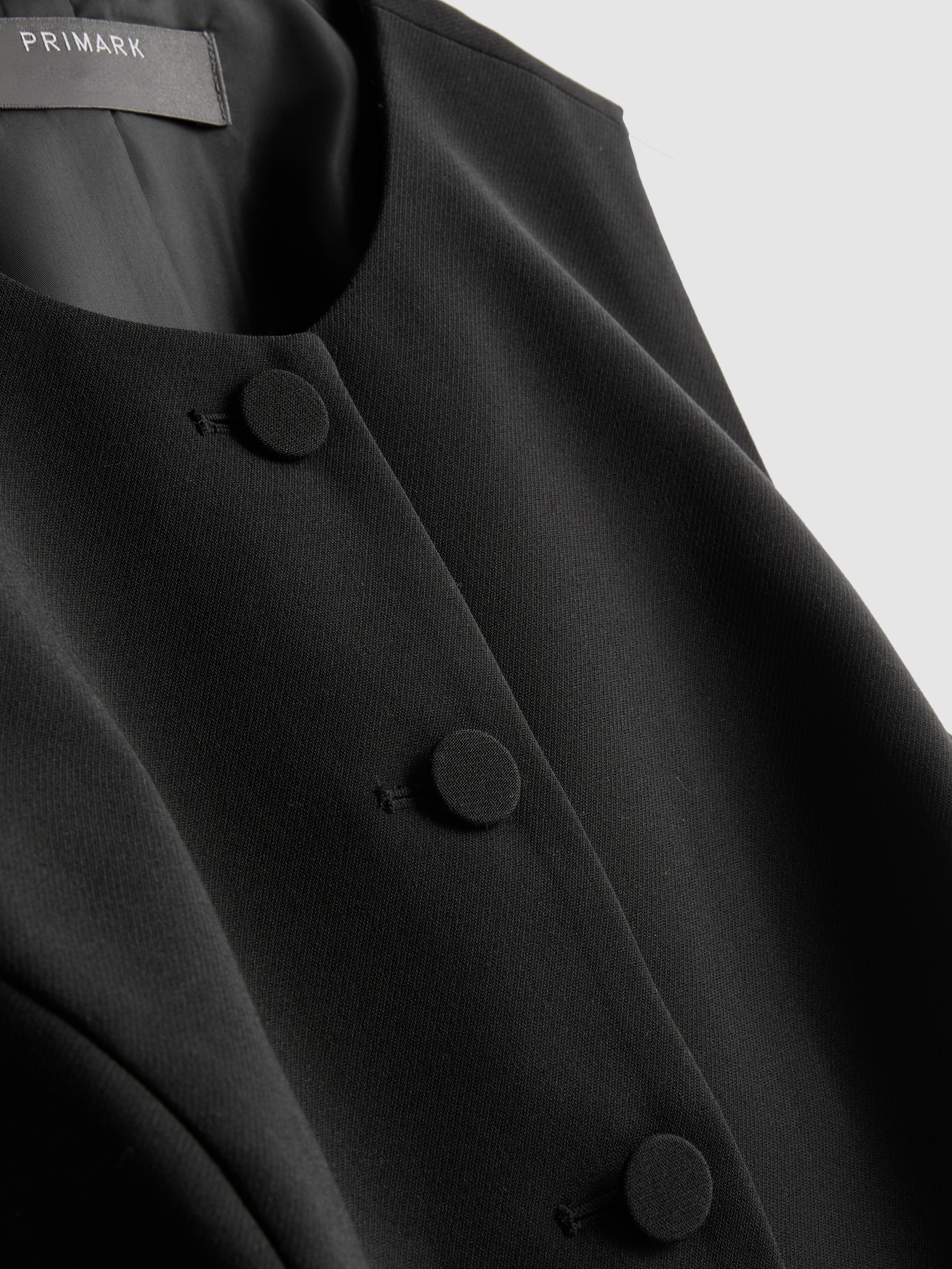 Vesta s peplum volánom a okrúhlym výstrihom