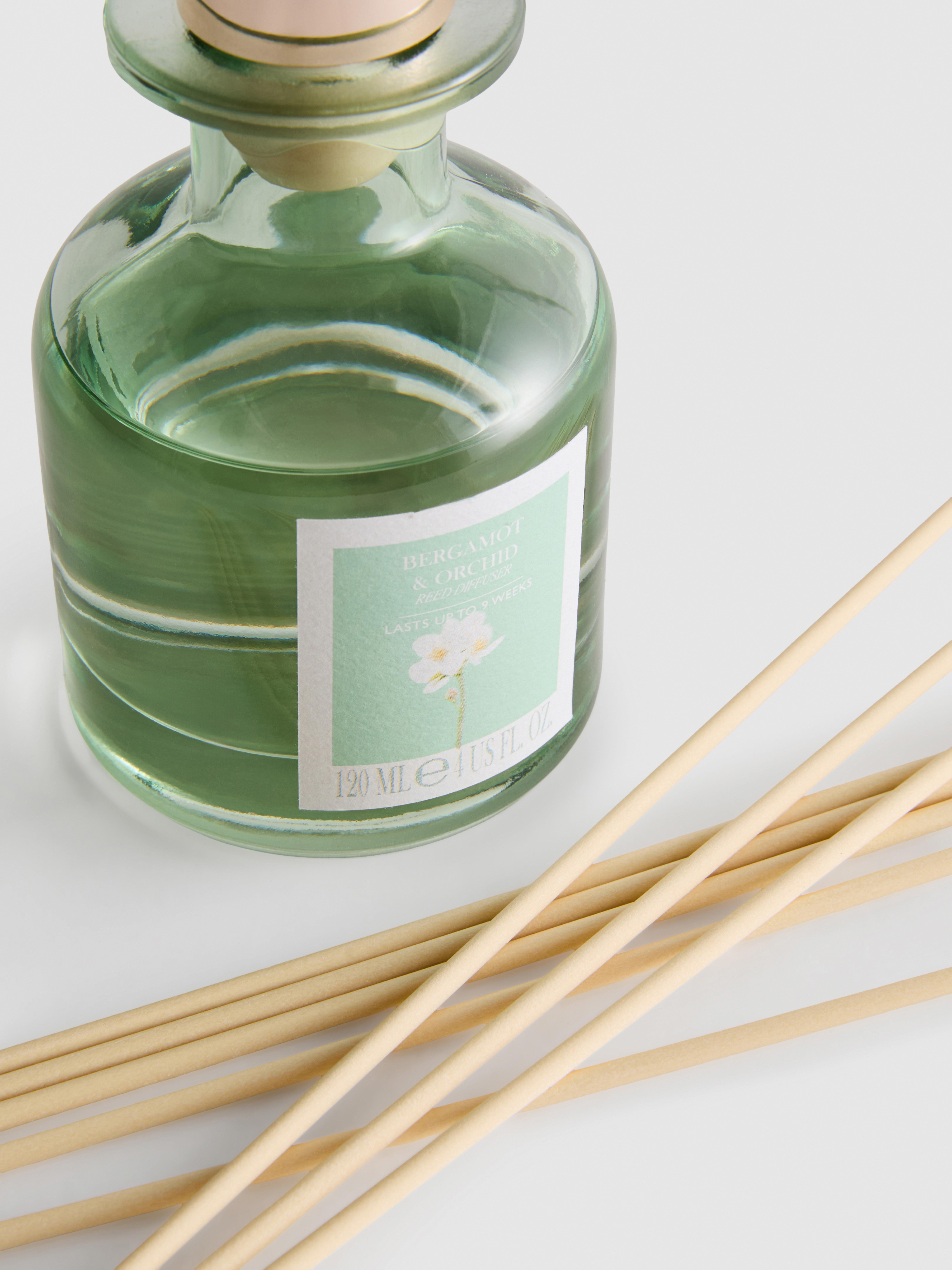 Diffuseur de parfum floral à bâtonnets dans un pot en verre