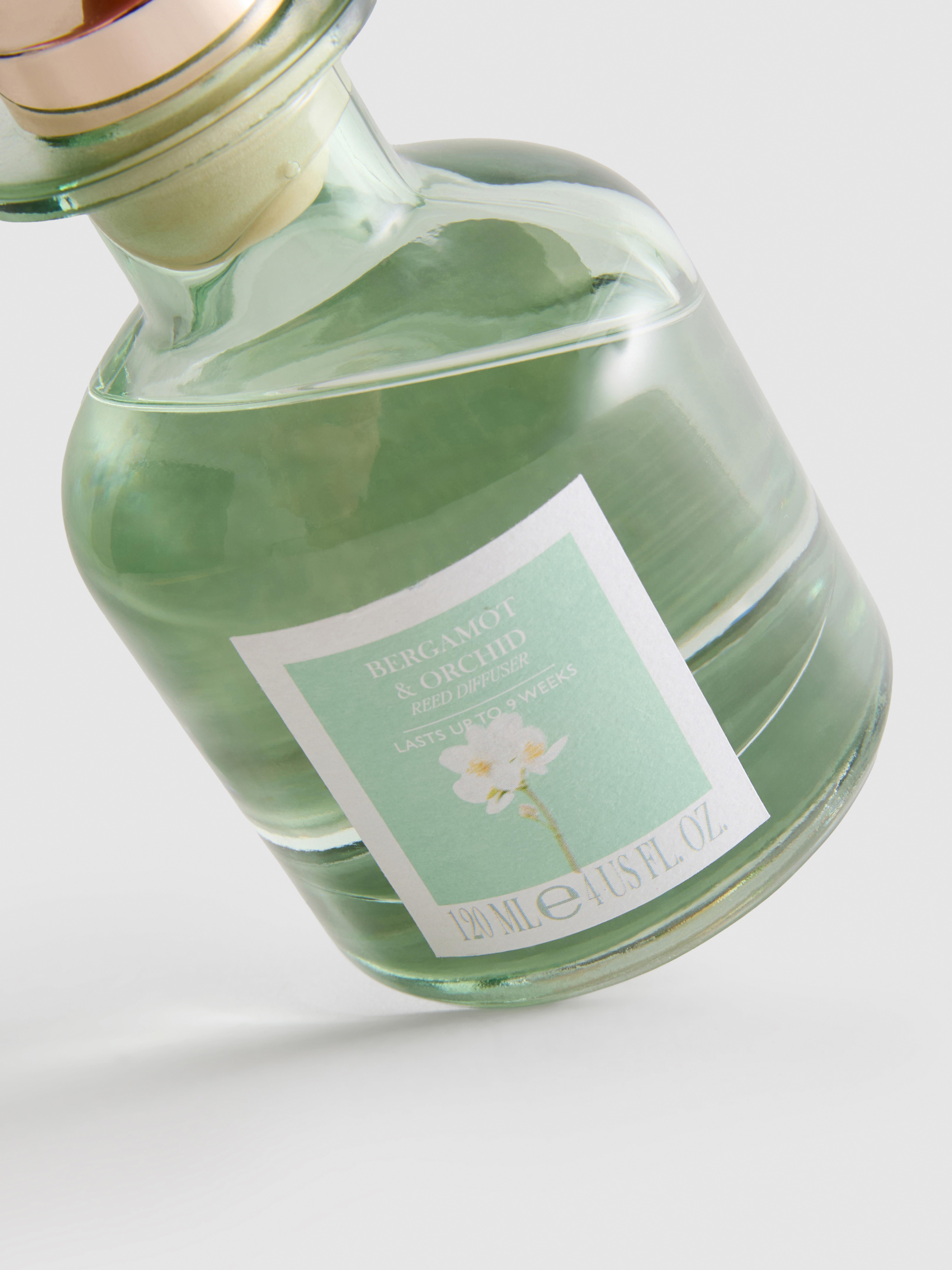 Diffuseur de parfum floral à bâtonnets dans un pot en verre