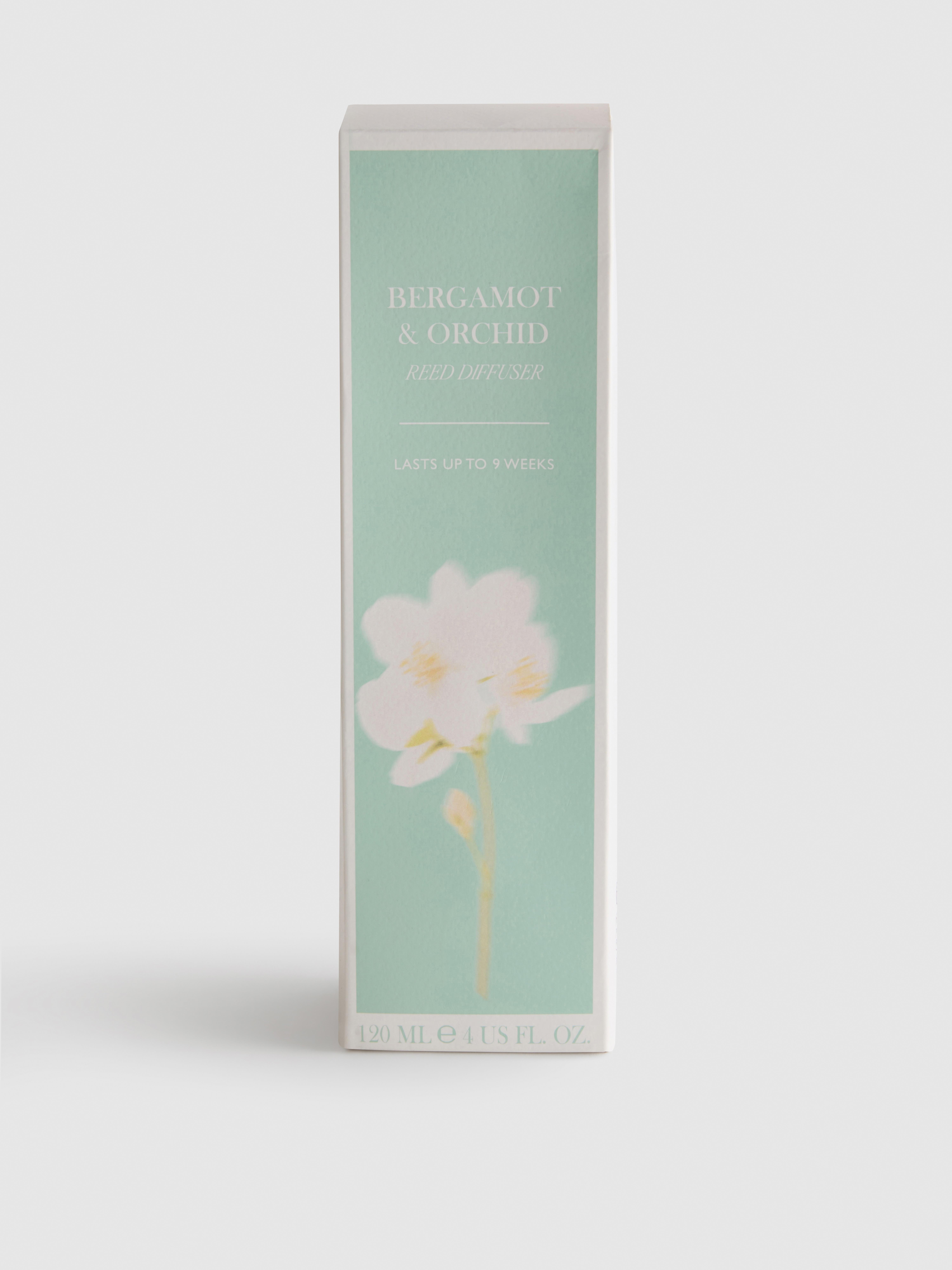 Diffuseur de parfum floral à bâtonnets dans un pot en verre