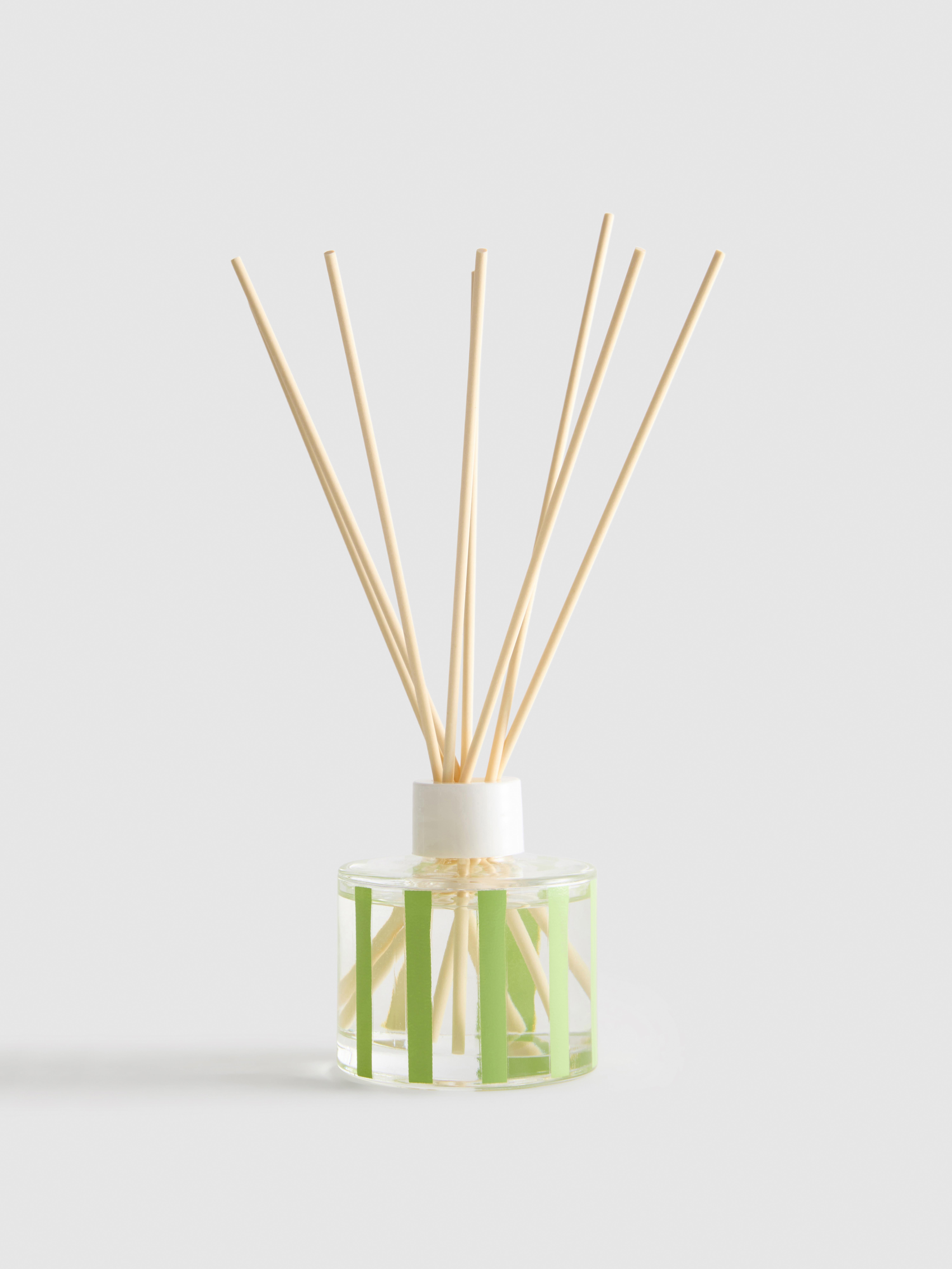 Geurstokjes in gestreepte glazen pot