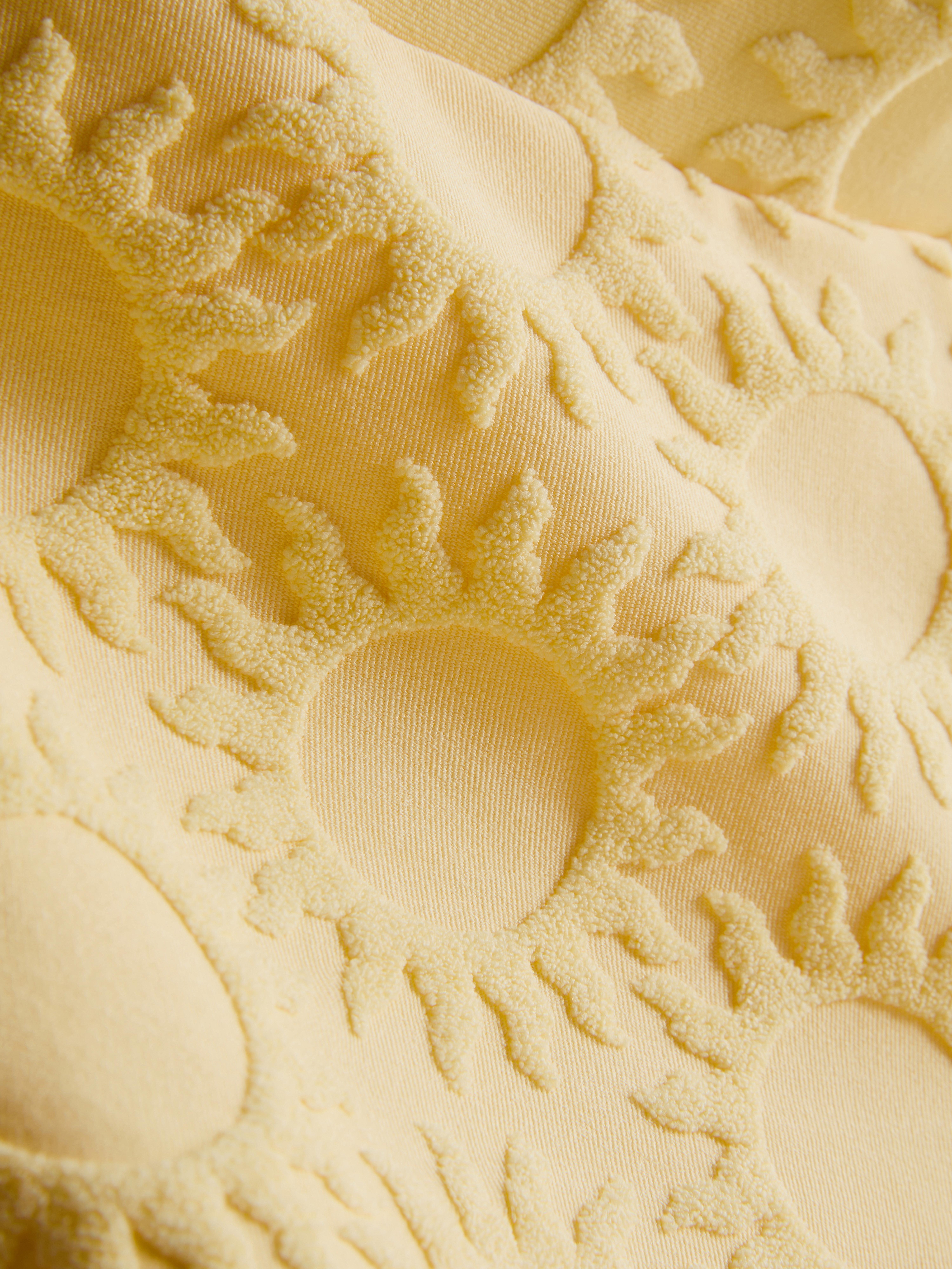 Strandshort met zonnemotief in reliëf