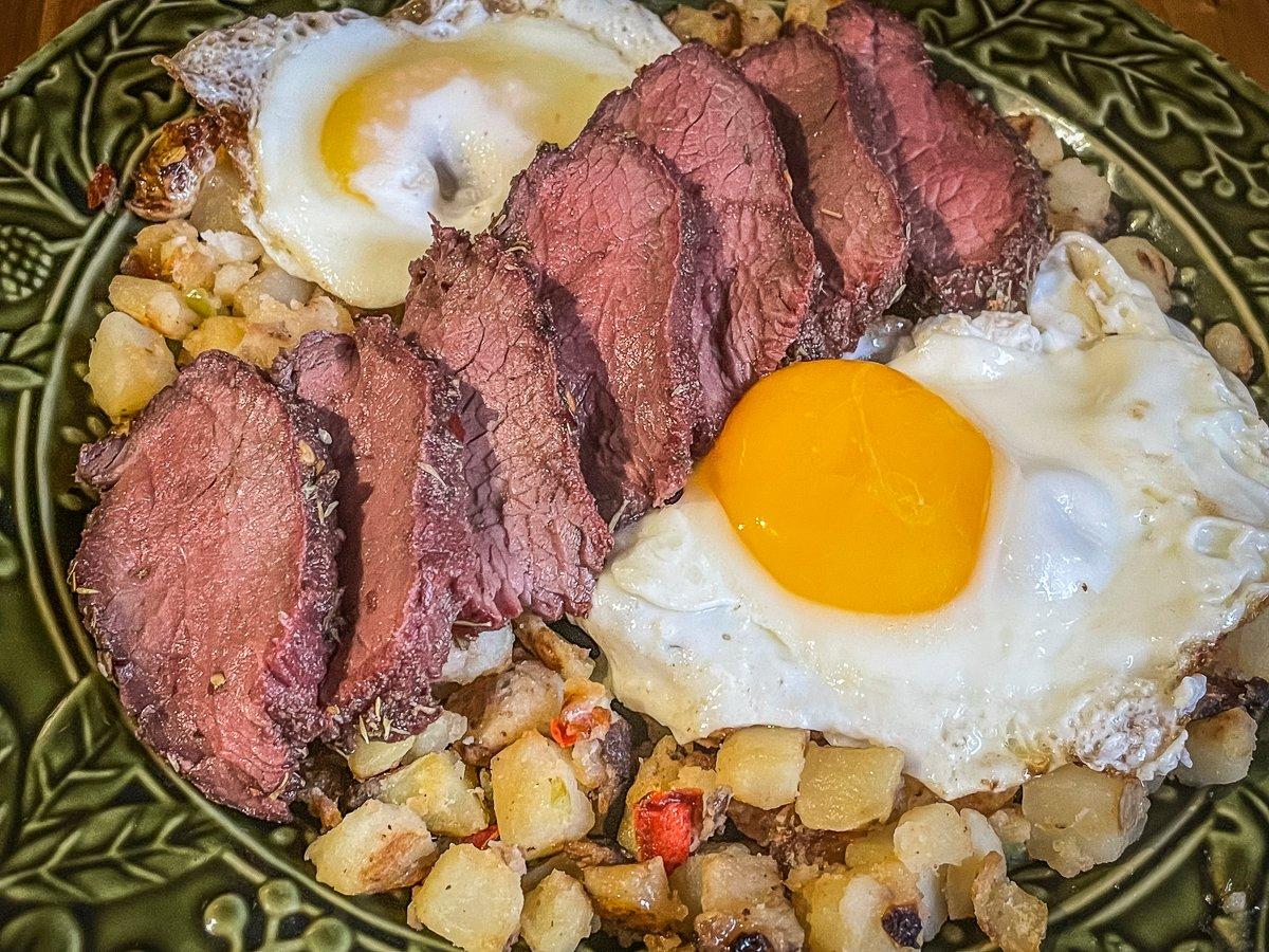 Layer the sliced grilled backstrap over fried eggs and hash browns.