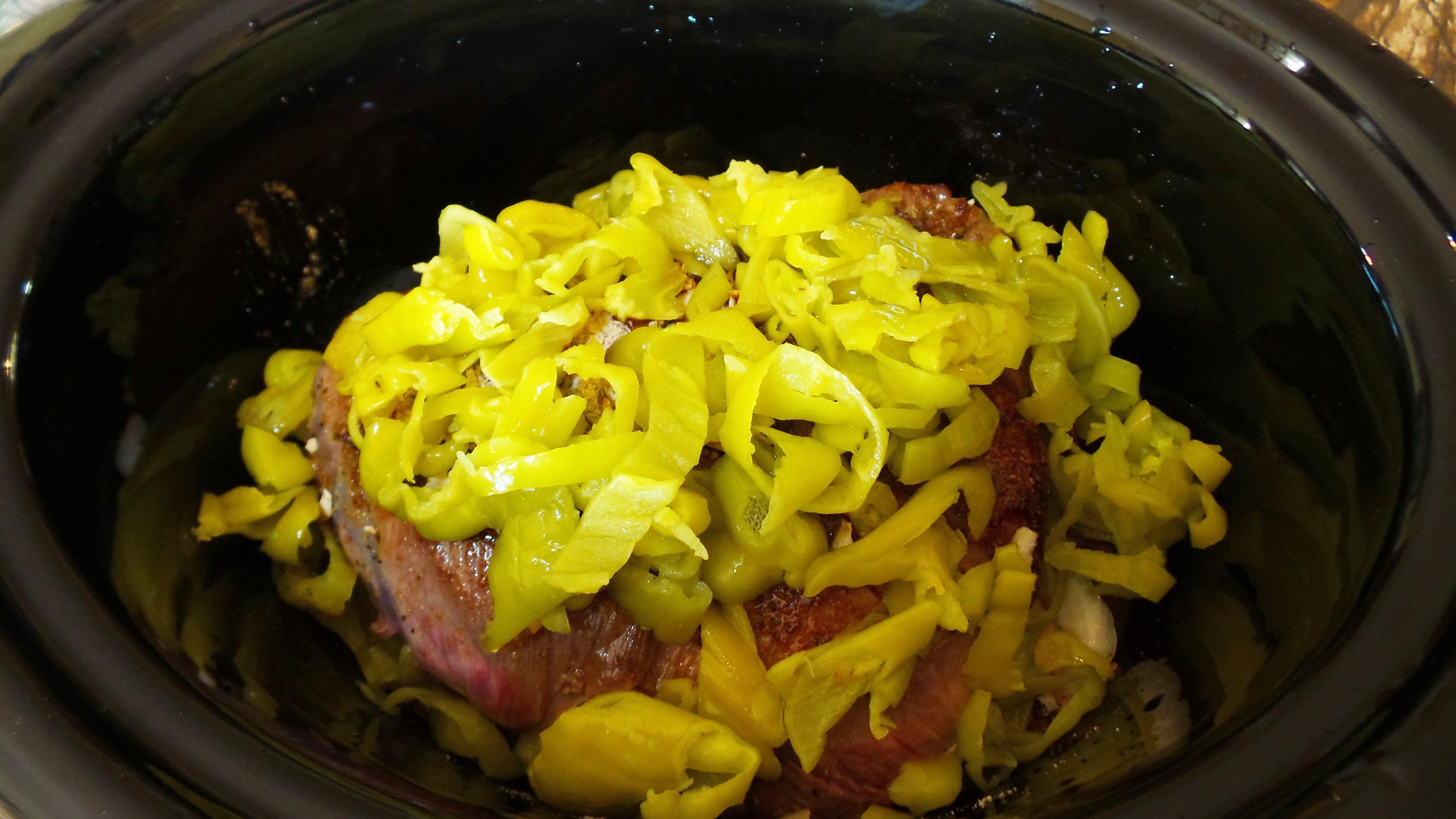 Add onions, roast, soup mix and peppers to slow cooker.