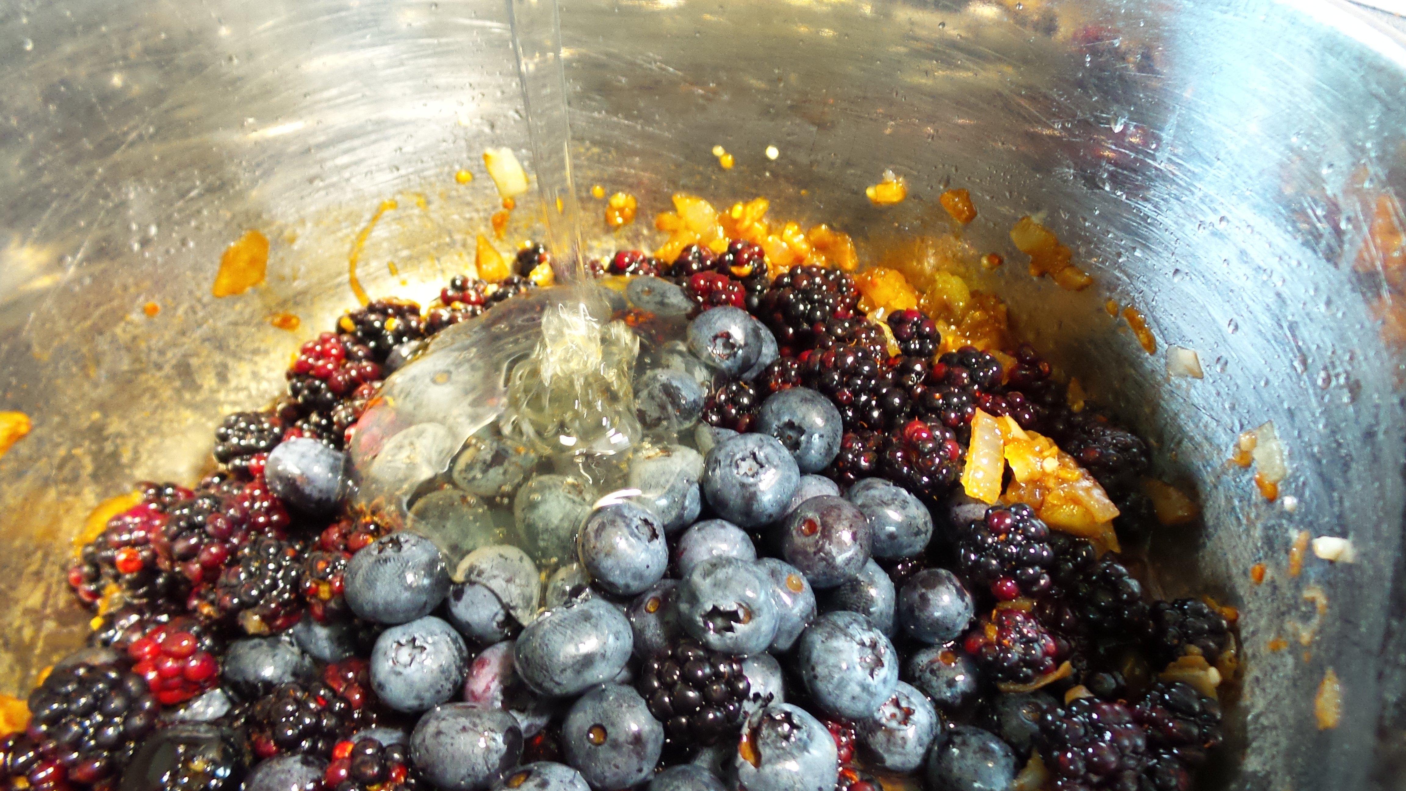 Add the berries and other sauce ingredients to the sauteed onions and garlic.