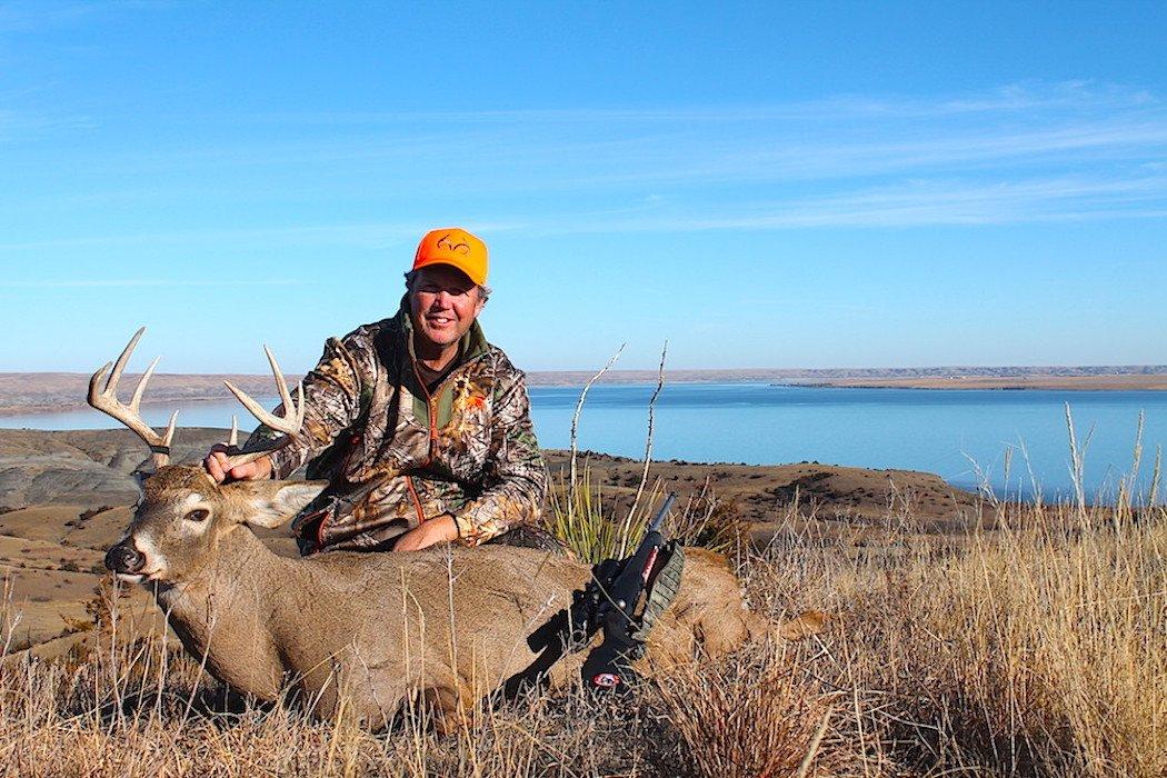 The author poses with a big, mature buck. (Doug Howlett photo)