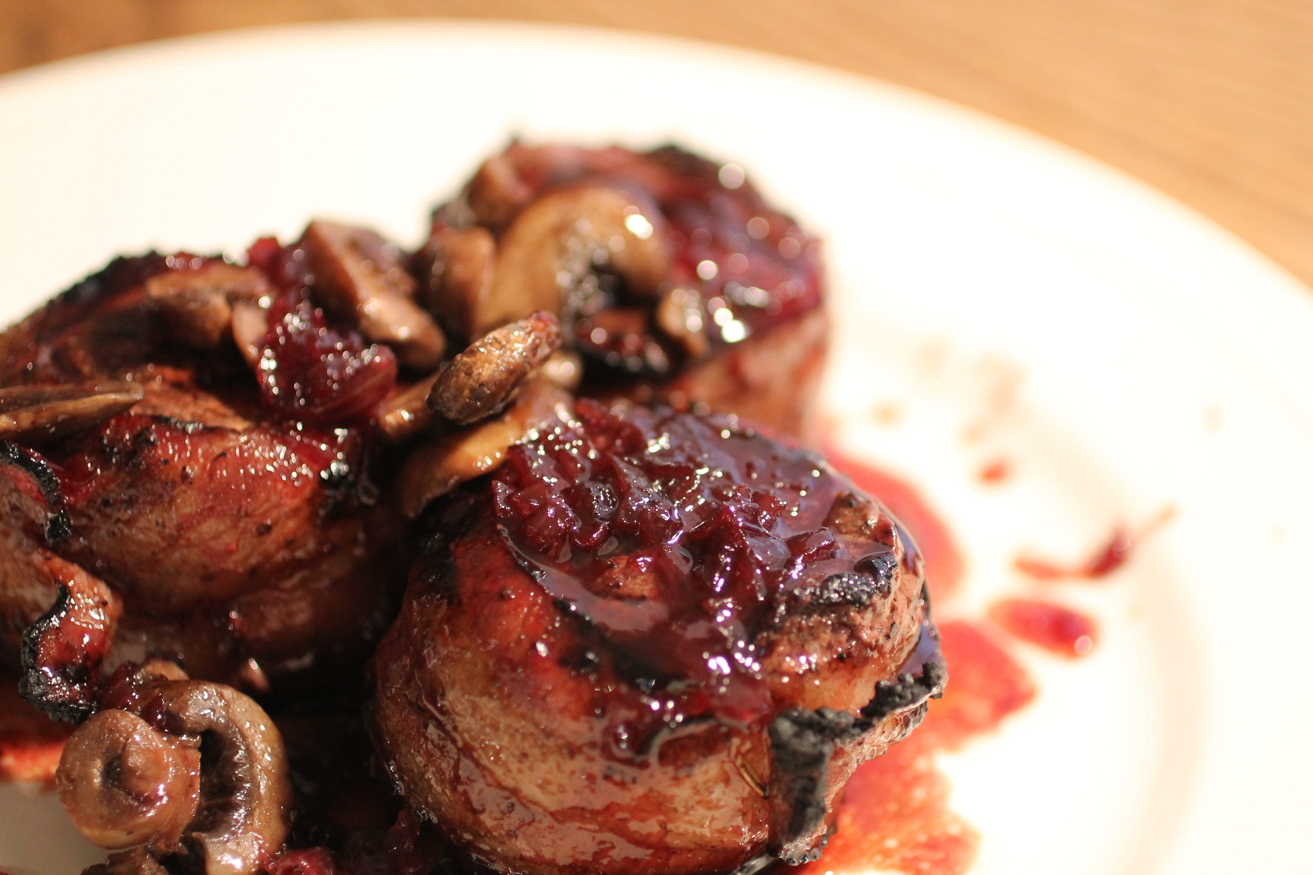 Bacon wrapped venison medallions with red wine sauce and mushrooms.
