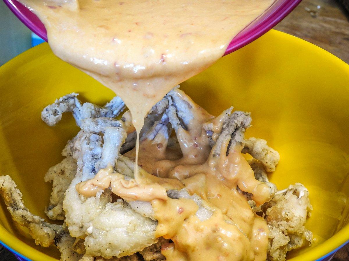 Coat the fried legs in sauce. A lidded bowl and a quick toss work well.