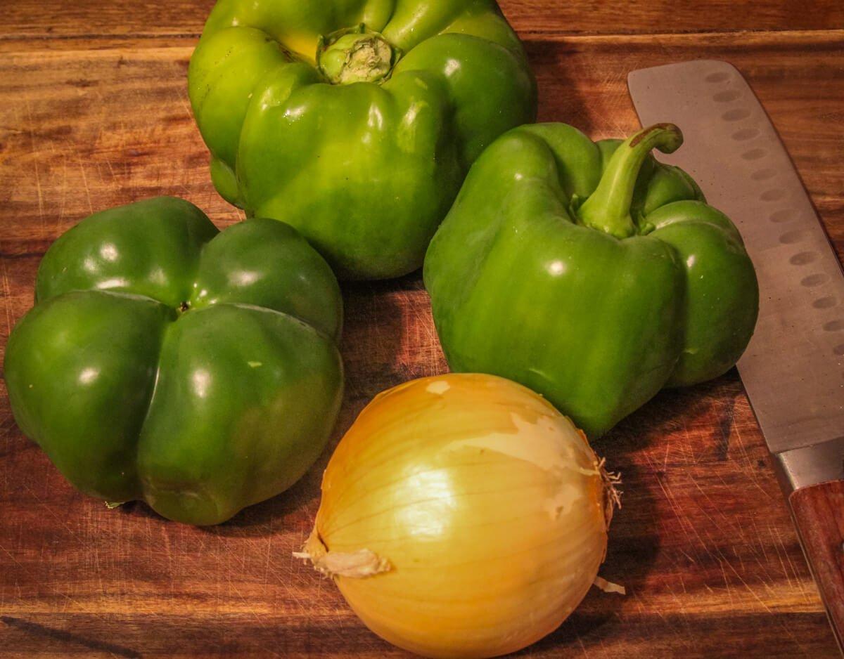 Start by giving three or four bell peppers and an onion a rough chop.