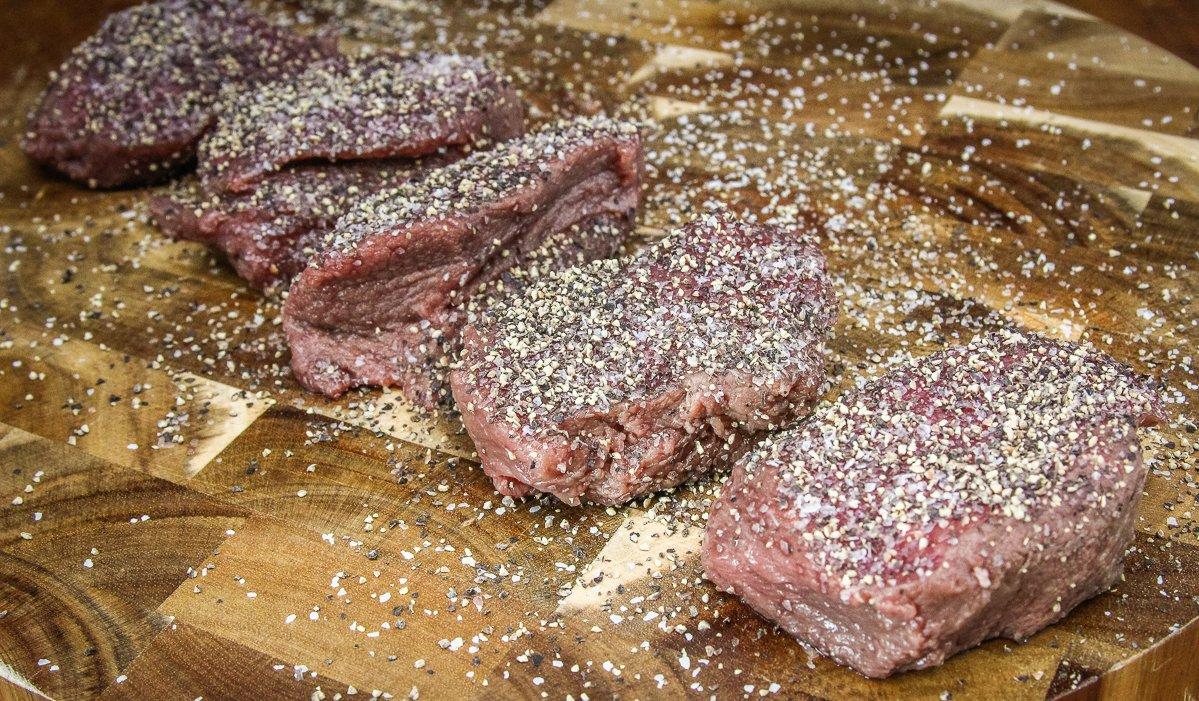 Season the backstrap well with salt and pepper before grilling.