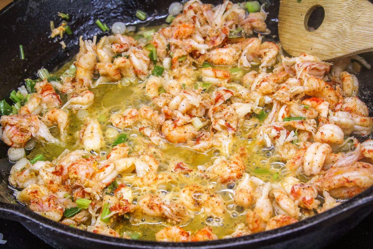 Sauté the green onions and crawfish tails. 