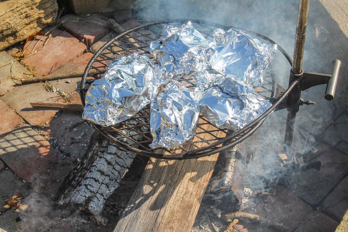 Place the sealed packets on a grill or directly in the edge of the campfire coals.
