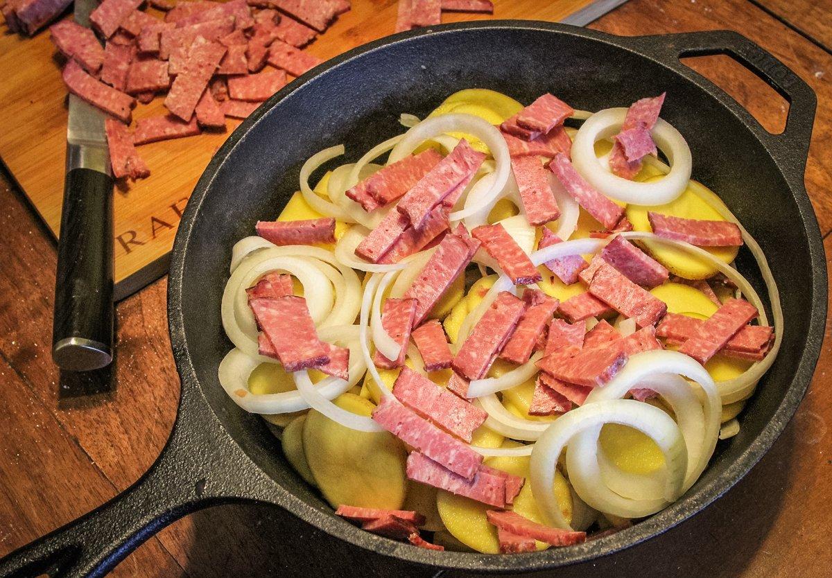 Layer potatoes, onions, and bacon in a deep Lodge skillet or Dutch oven.