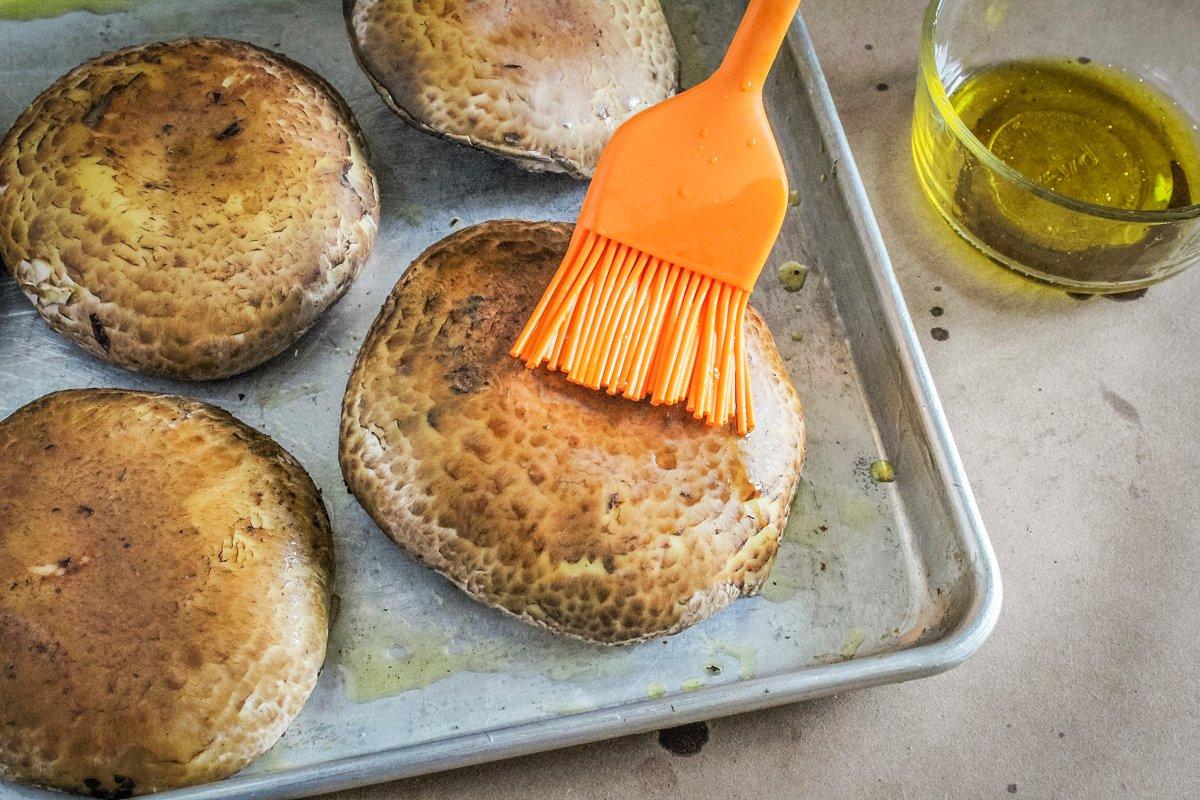 Brush both sides of the mushrooms with olive oil.