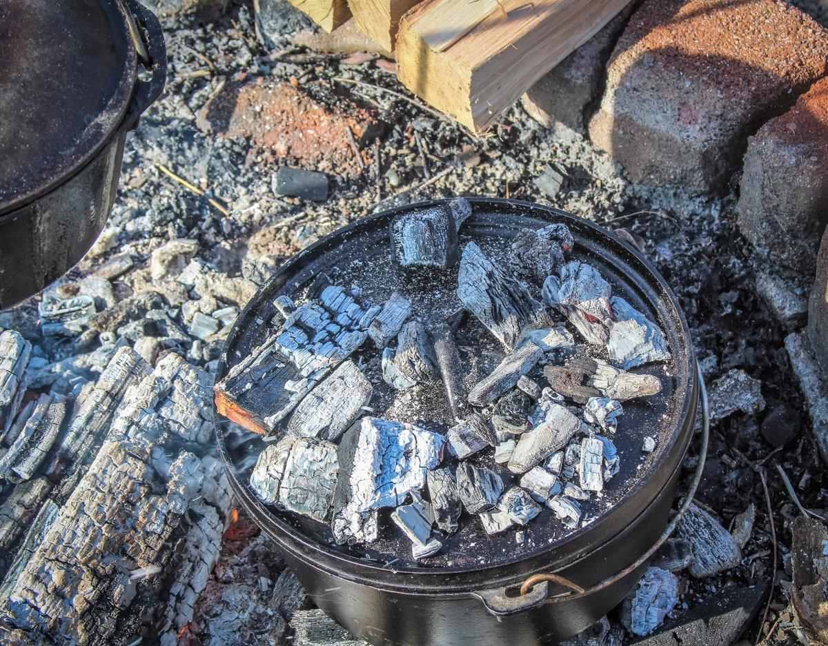 Cover the pot and add coals to the lid for even baking heat.