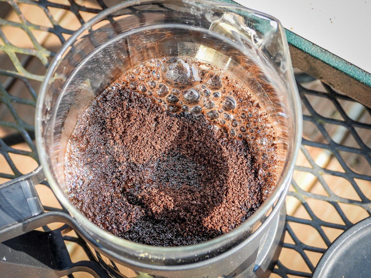Use a spoon to agitate and moisten the grounds before pressing the coffee.