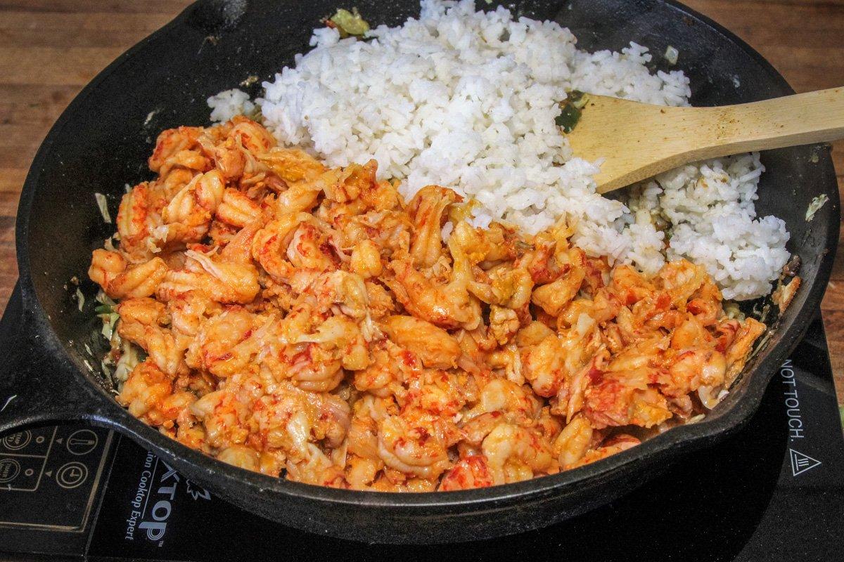 Add the crawfish tails and rice to the pan.