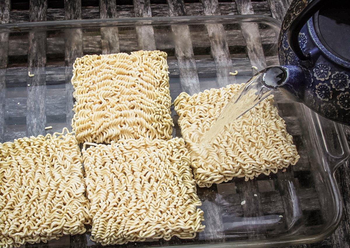 Pour boiling water over the ramen noodles to soften them before adding to the wok.