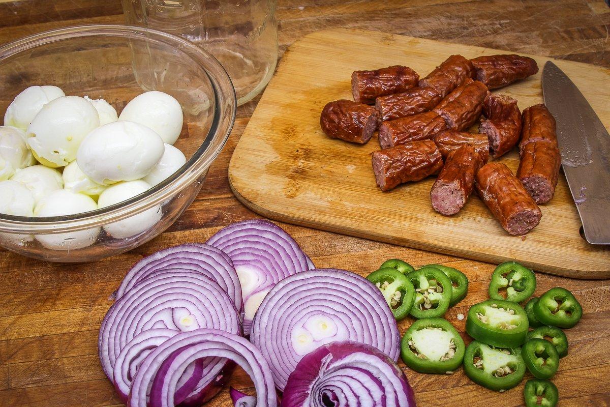 Slice the onions and peppers, cut the sausage into links and peel the boiled eggs.