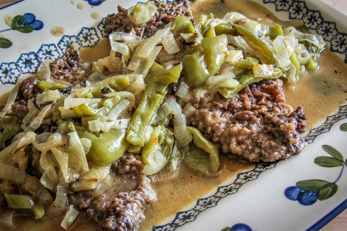 Serve the elk steak topped with the peppers and and onions and lots of gravy.