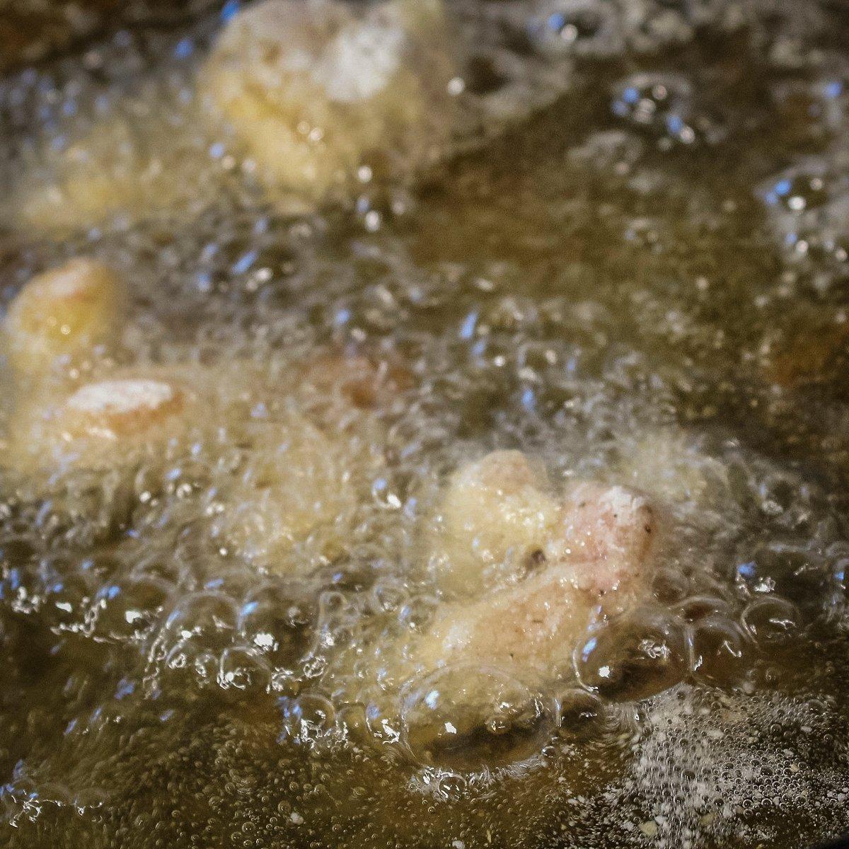 Once your fish has finished frying, gently drop the dredged eggs into the hot oil.